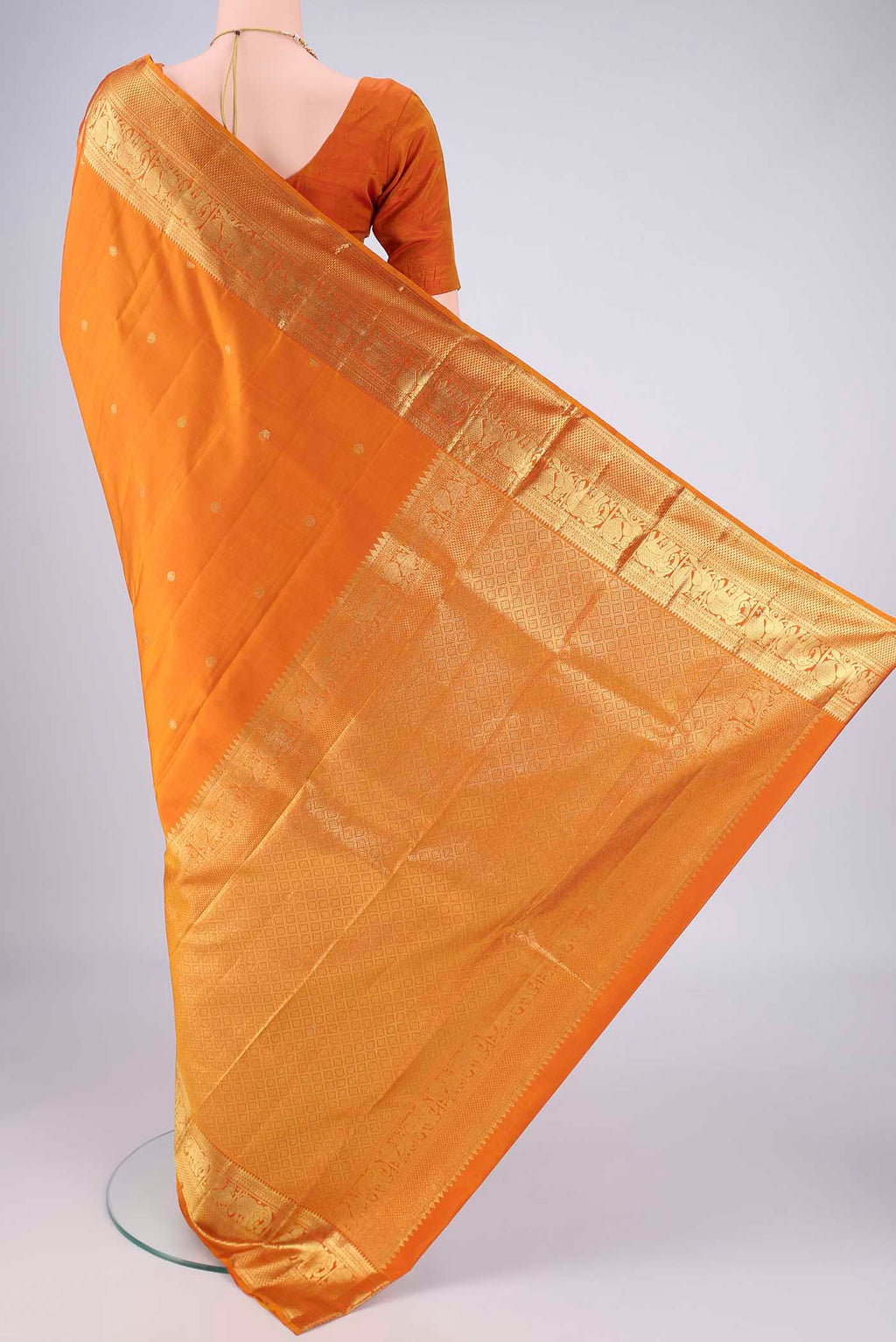 Flat view of Brick Orange Kanchipuram Silk Saree with Zari Butta on the body and Zari Border. 