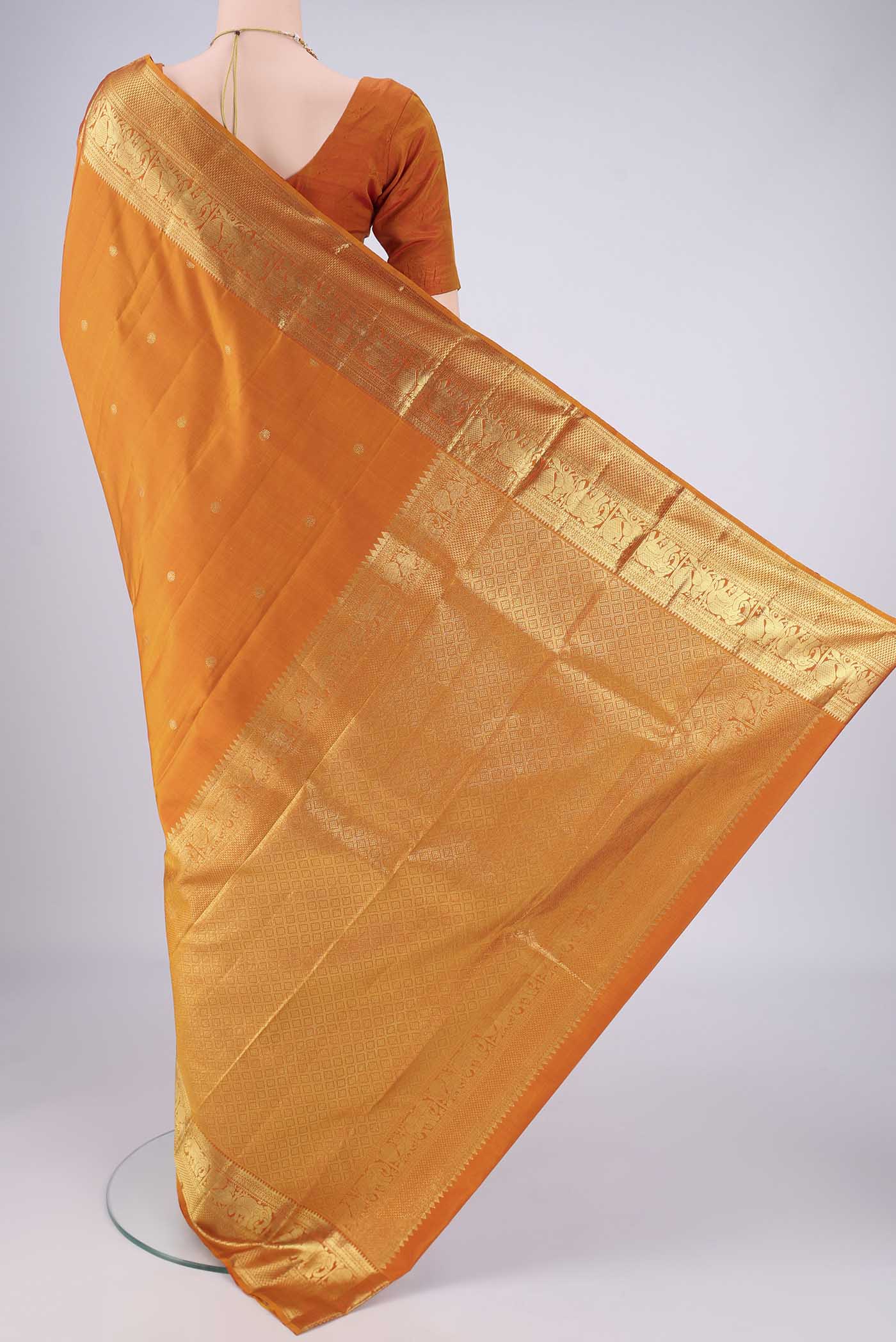 Flat view of Brick Orange Kanchipuram Silk Saree with Zari Butta on the body and Zari Border. 
