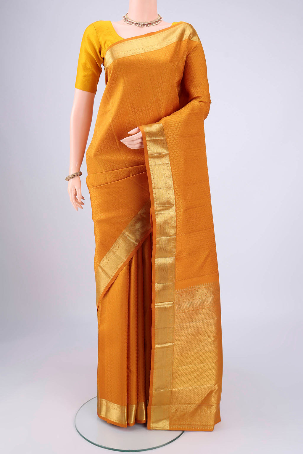Mustard Kanjivaram Silk Saree with Jacquard design on the body and Zari Border.  displayed on a mannequin