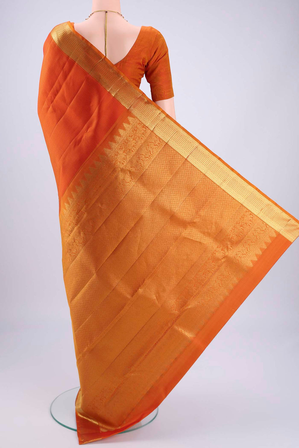 Flat view of Rust Kanjivaram Silk Saree with Jacquard design on the body and Zari Border. 
