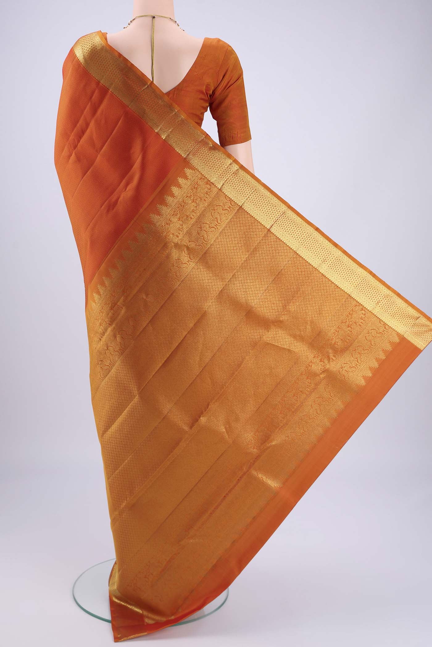 Flat view of Rust Kanjivaram Silk Saree with Jacquard design on the body and Zari Border. 
