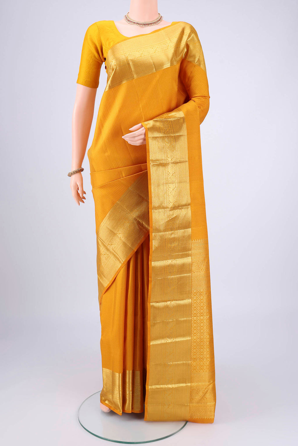 Mustard Kanjivaram Silk Saree with Jacquard design on the body and Zari Border.  displayed on a mannequin