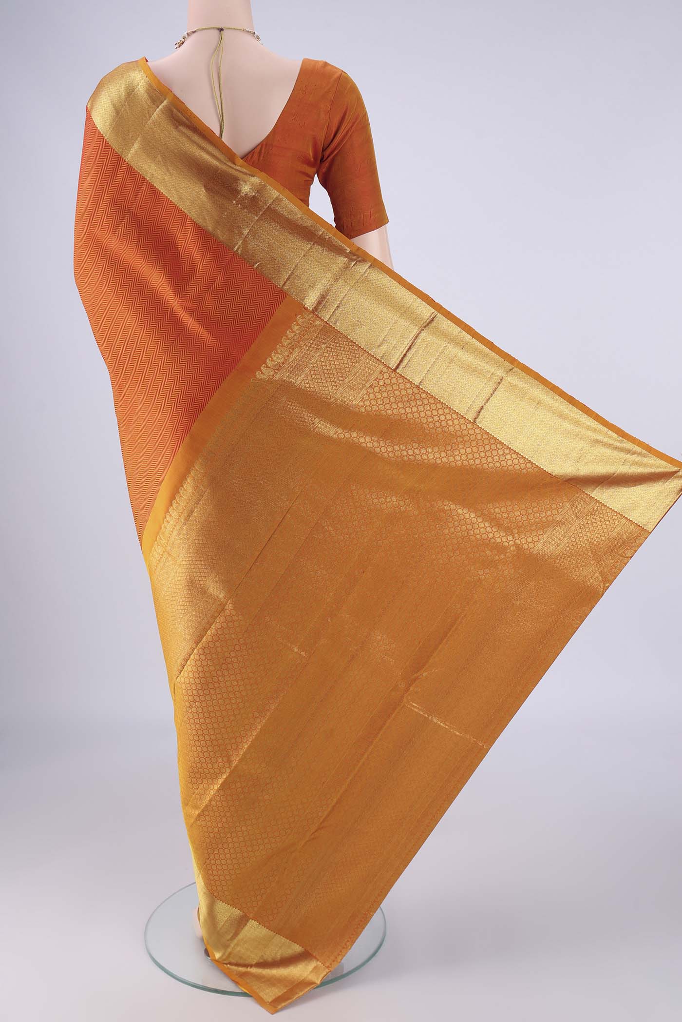 Flat view of Orange Kanjivaram Silk Saree with Jacquard design on the body and Zari Border. 