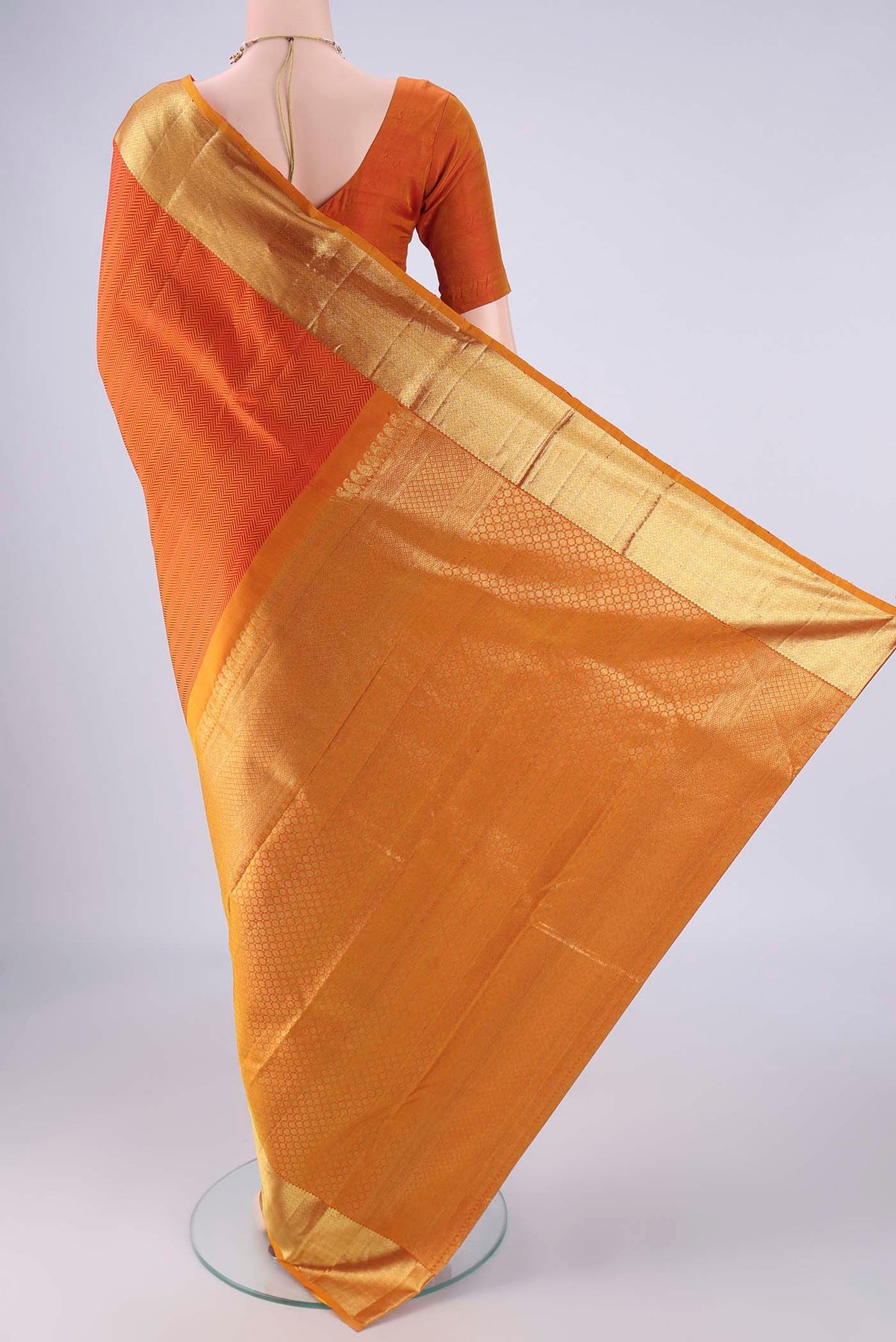 Flat view of Orange Kanjivaram Silk Saree with Jacquard design on the body and Zari Border. 