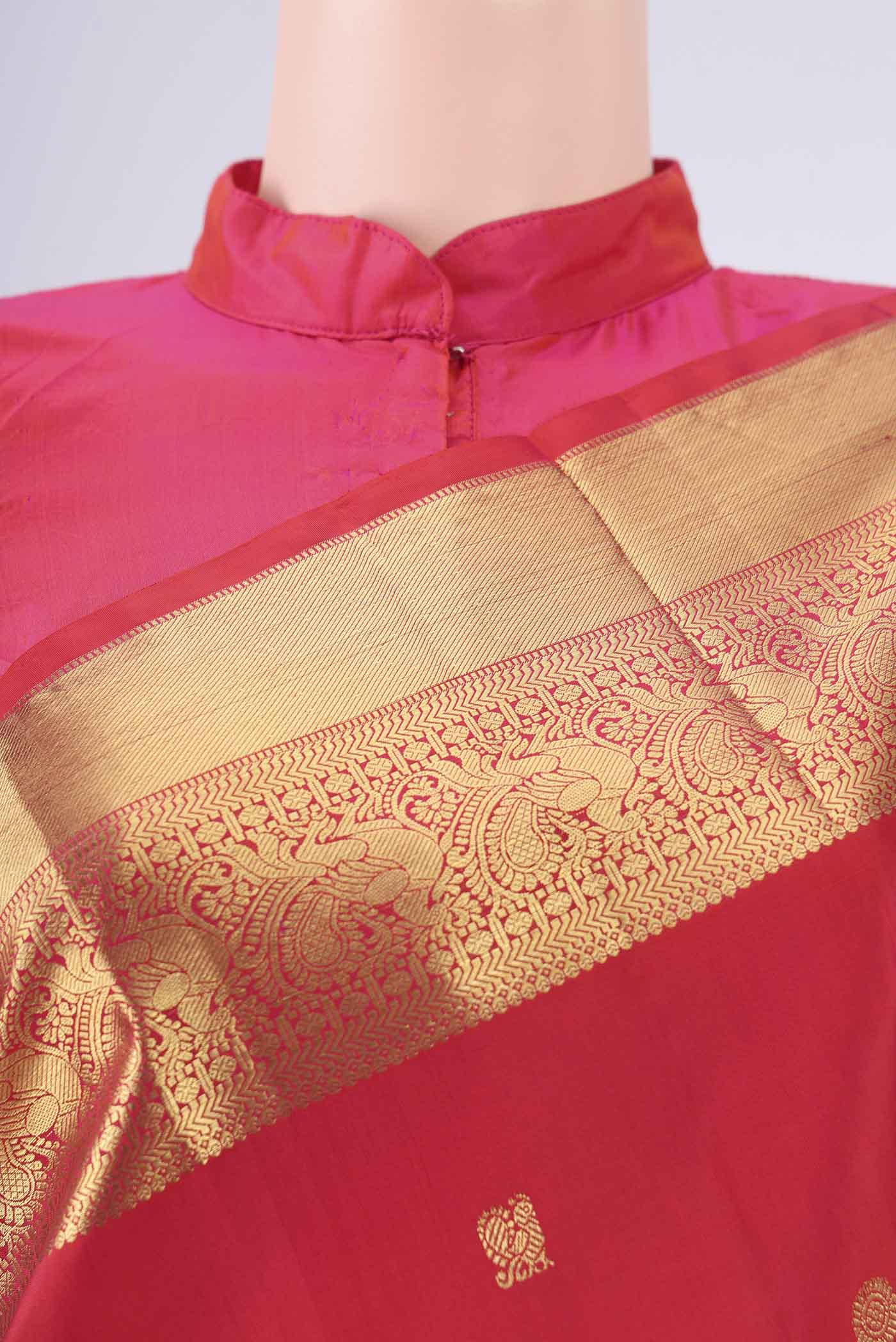 Red Dual Tone Kanchipuram Saree with Zari Butta on the body and Zari Border.  displayed on a mannequin