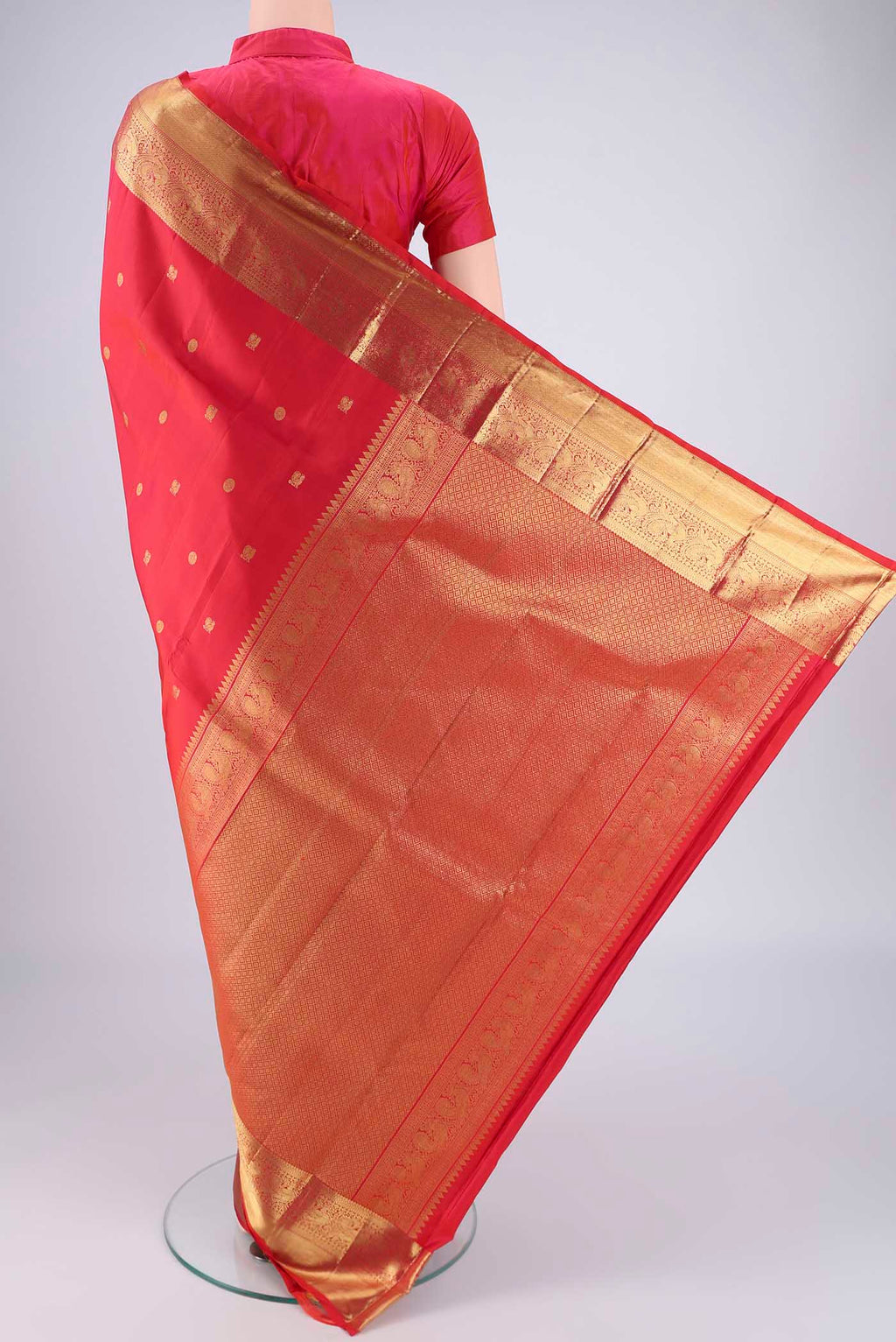 Flat view of Red Dual Tone Kanchipuram Saree with Zari Butta on the body and Zari Border. 