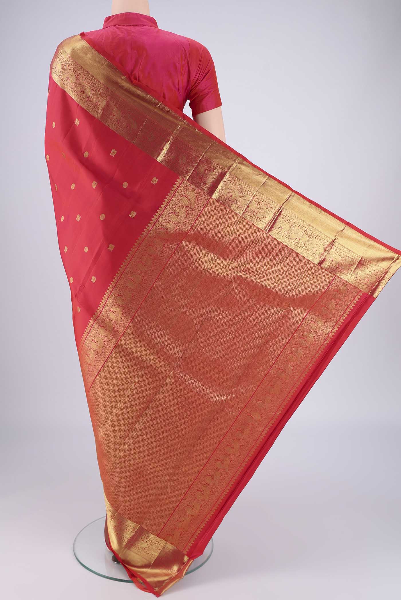Flat view of Red Dual Tone Kanchipuram Saree with Zari Butta on the body and Zari Border. 