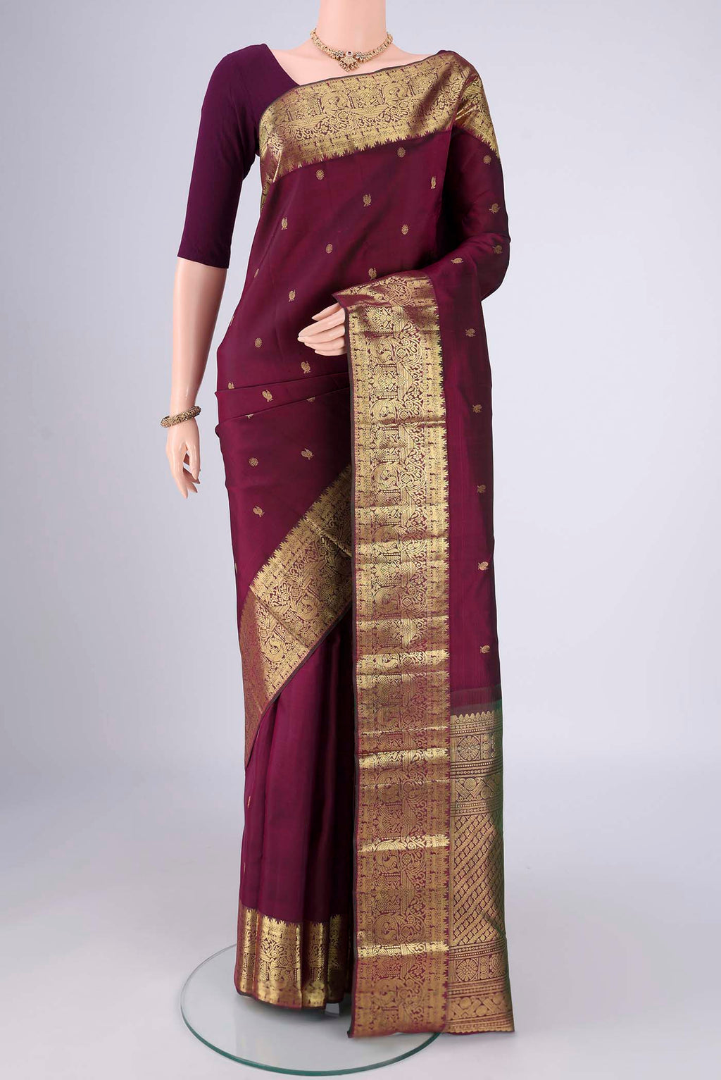 Pure Silk Pure Zari Maroon Kanchipuram Saree with Zari Butta on the body and Zari Border.  displayed on a mannequin