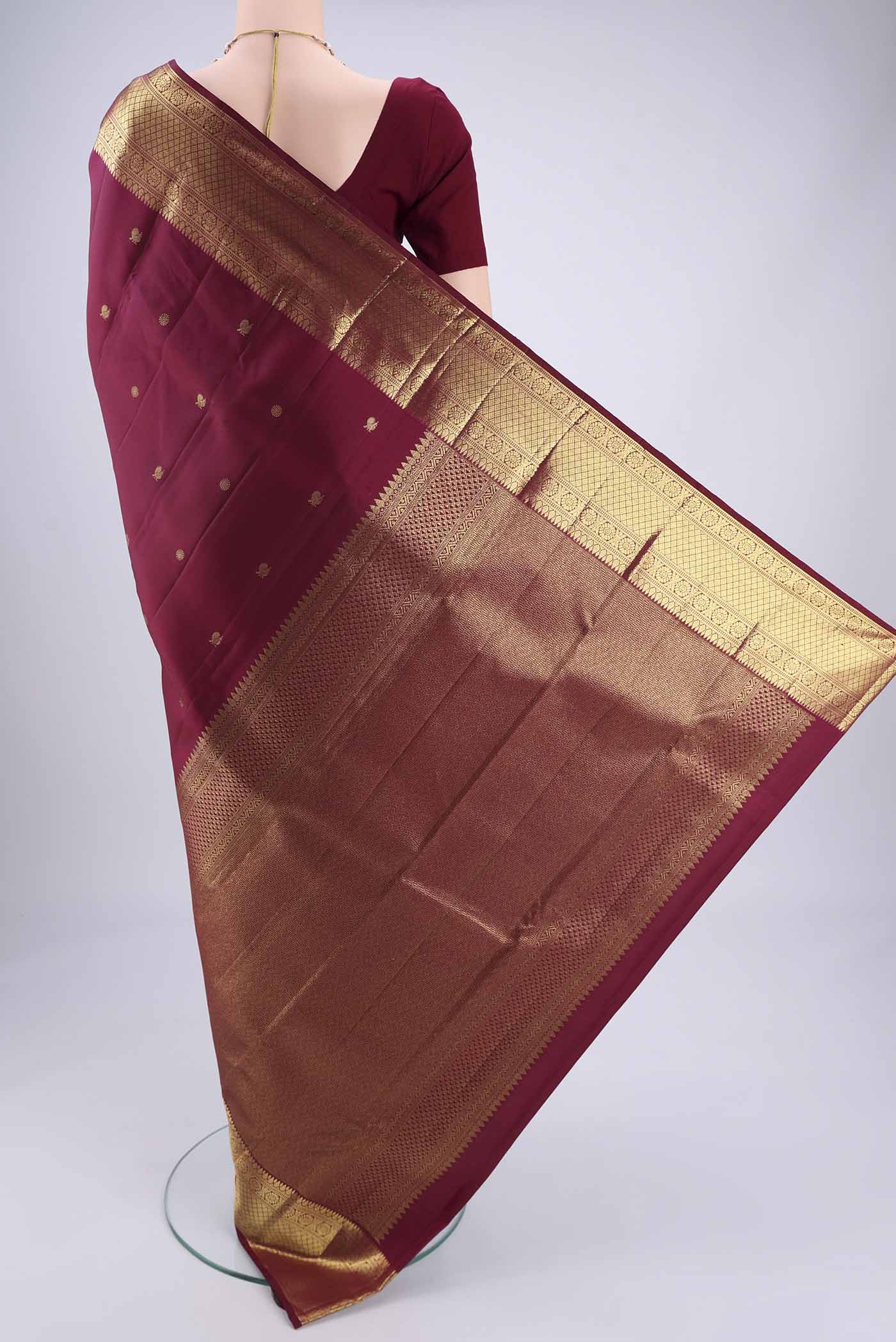 Flat view of Maroon Kanchipuram Silk Saree with Zari Butta on the body and Zari Border. 