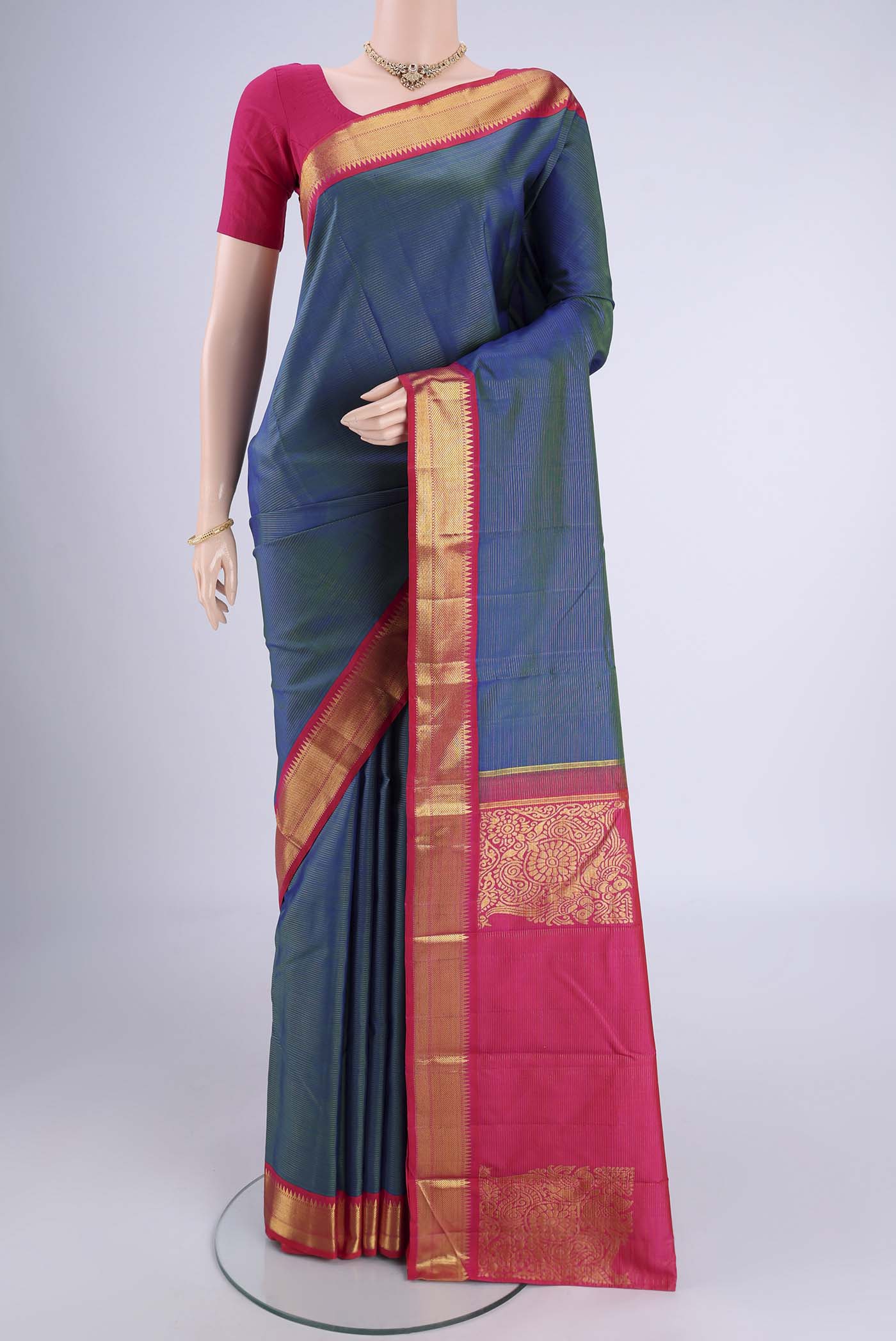 Peacock Blue Kanchipuram Silk Saree with Stripes on the body and Zari Border.  displayed on a mannequin
