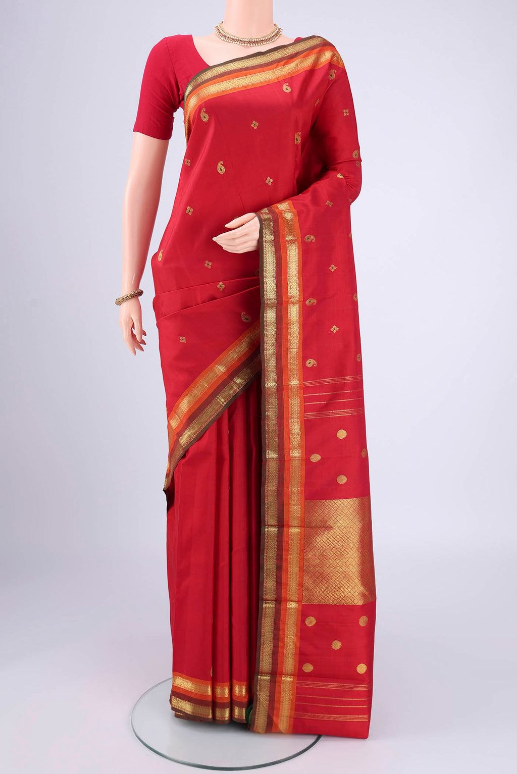 Red Kanjivaram Silk Saree with Zari Butta on the body and Zari Border.  displayed on a mannequin