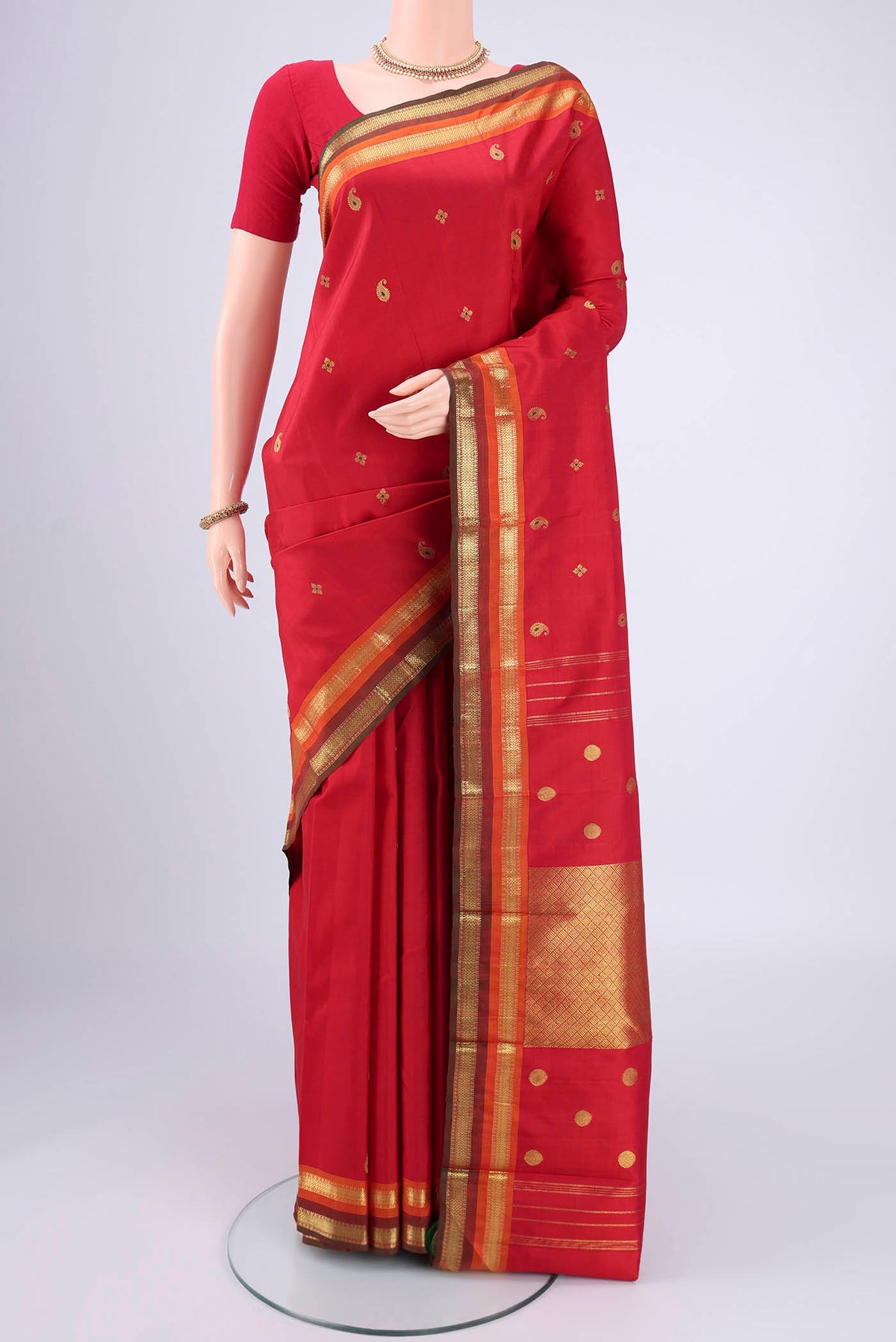 Red Kanjivaram Silk Saree with Zari Butta on the body and Zari Border.  displayed on a mannequin