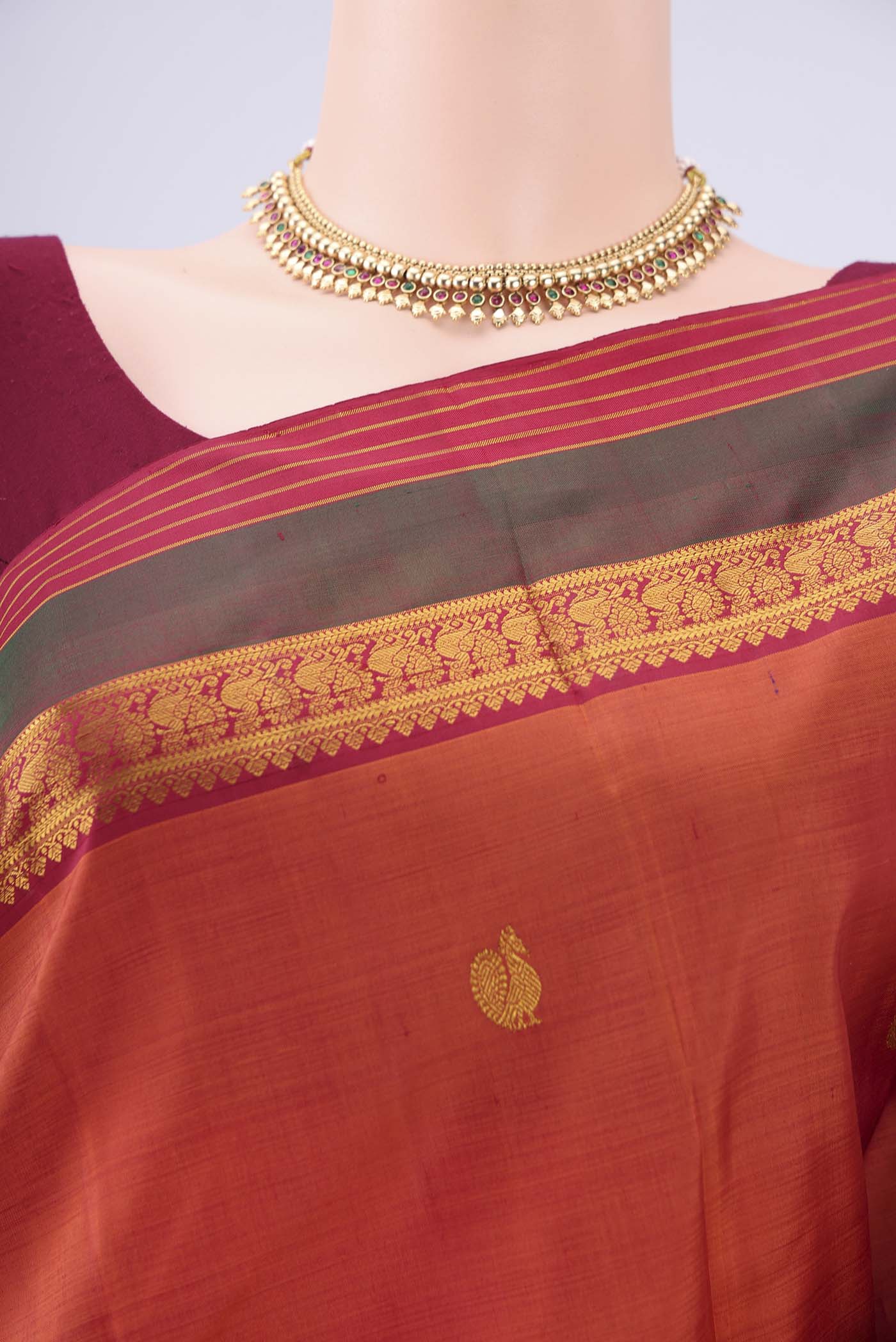 Border image of Rust Kanjivaram Silk Saree with Zari Butta on the body and Zari Border. 