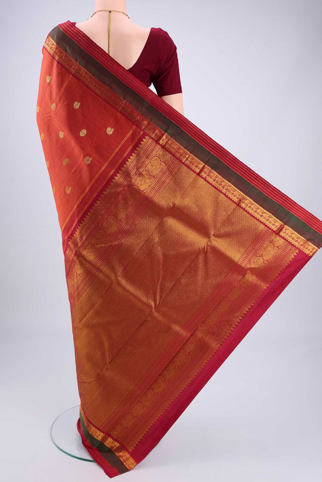Flat view of Rust Kanjivaram Silk Saree with Zari Butta on the body and Zari Border. 