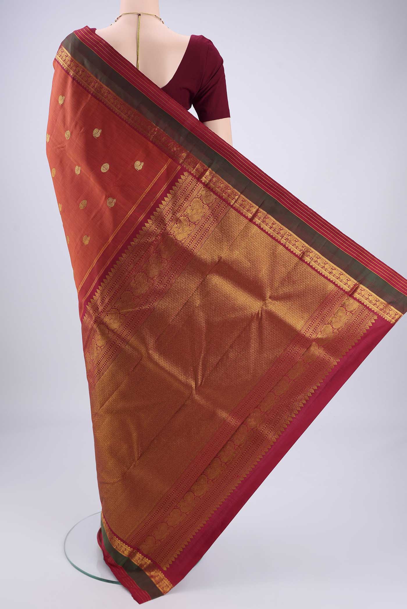 Flat view of Rust Kanjivaram Silk Saree with Zari Butta on the body and Zari Border. 