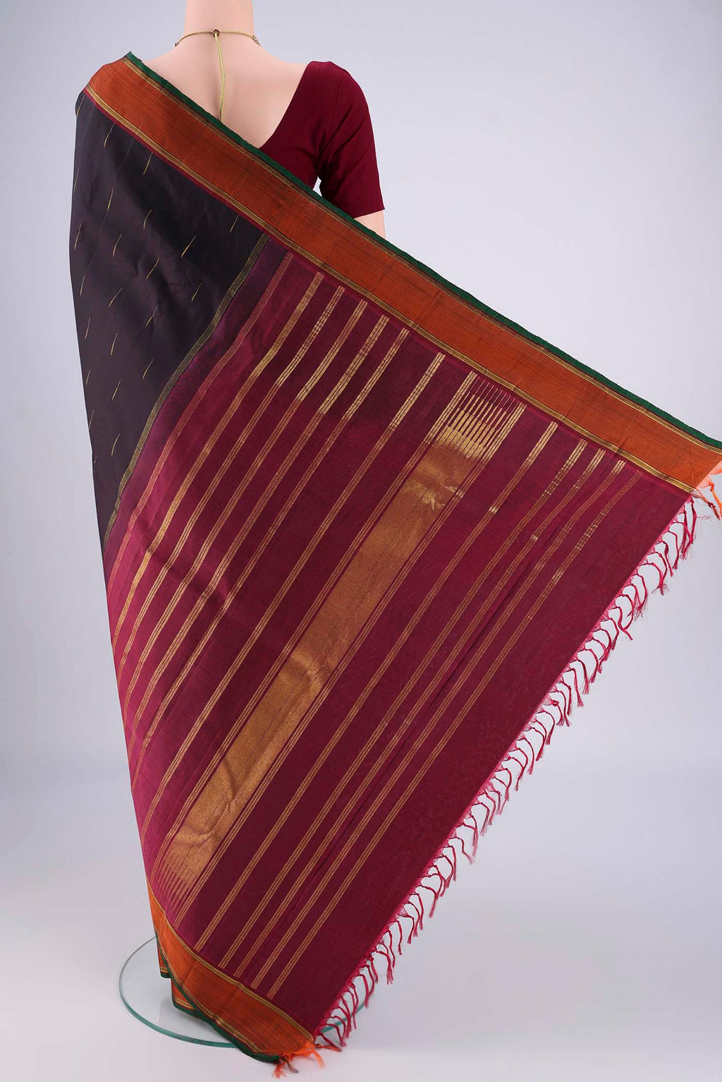 Flat view of Black Kanchipuram Saree with Zari Butta on the body and Zari Border. 