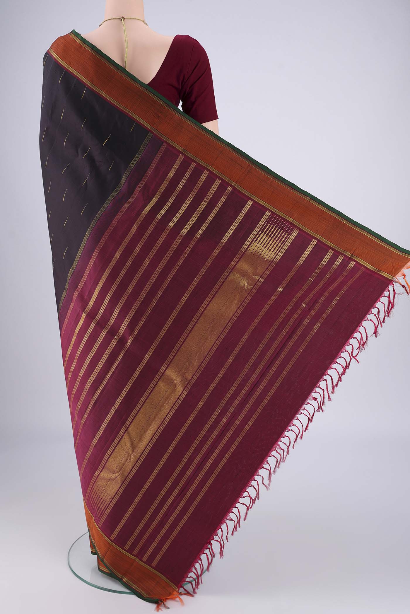 Flat view of Black Kanchipuram Saree with Zari Butta on the body and Zari Border. 