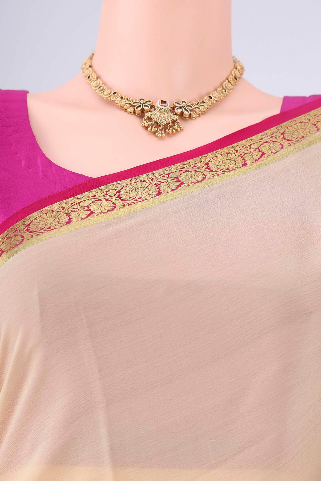 Beige Mysore Georgette Saree with Plain Body and Zari Border.  displayed on a mannequin