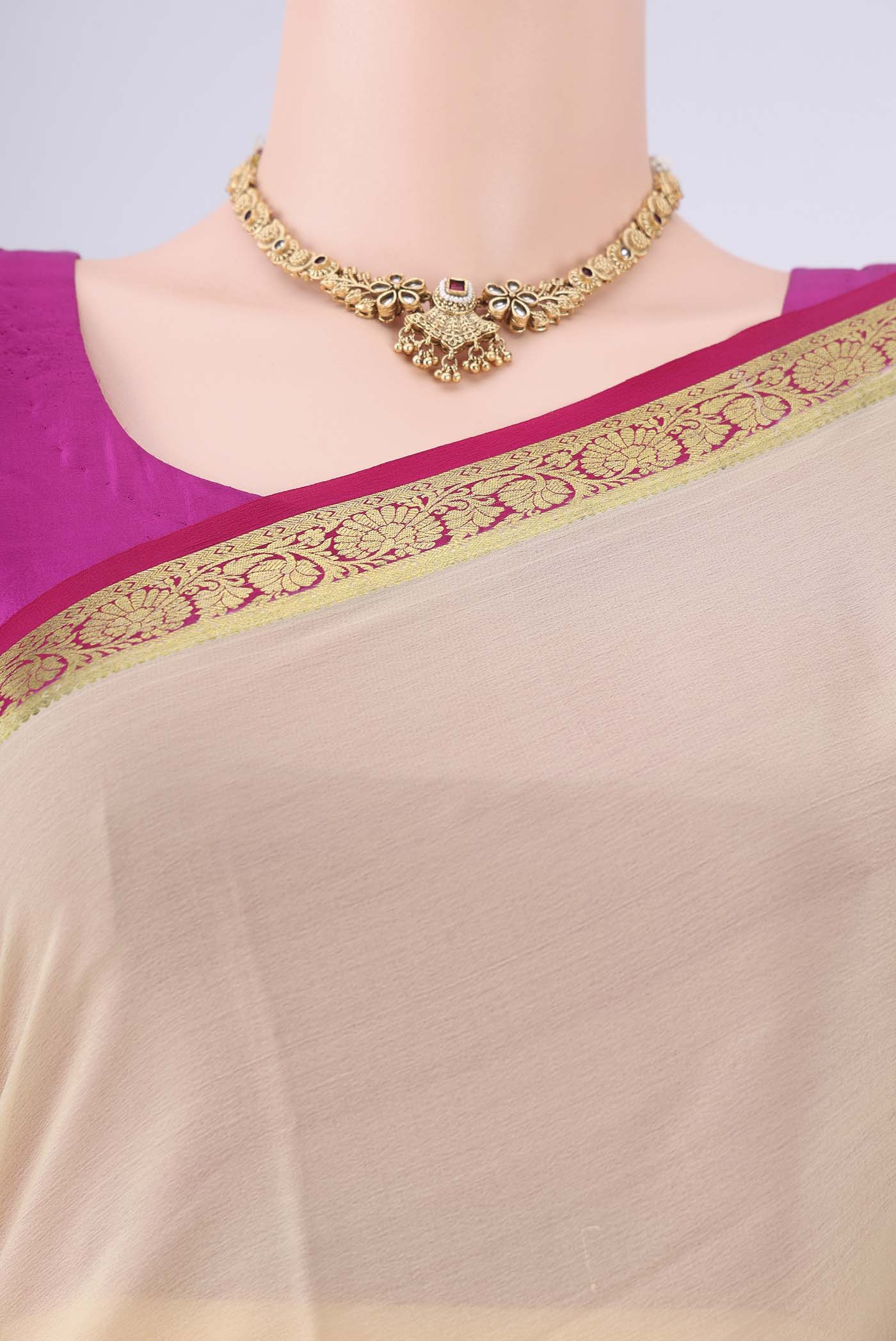 Beige Mysore Georgette Saree with Plain Body and Zari Border.  displayed on a mannequin
