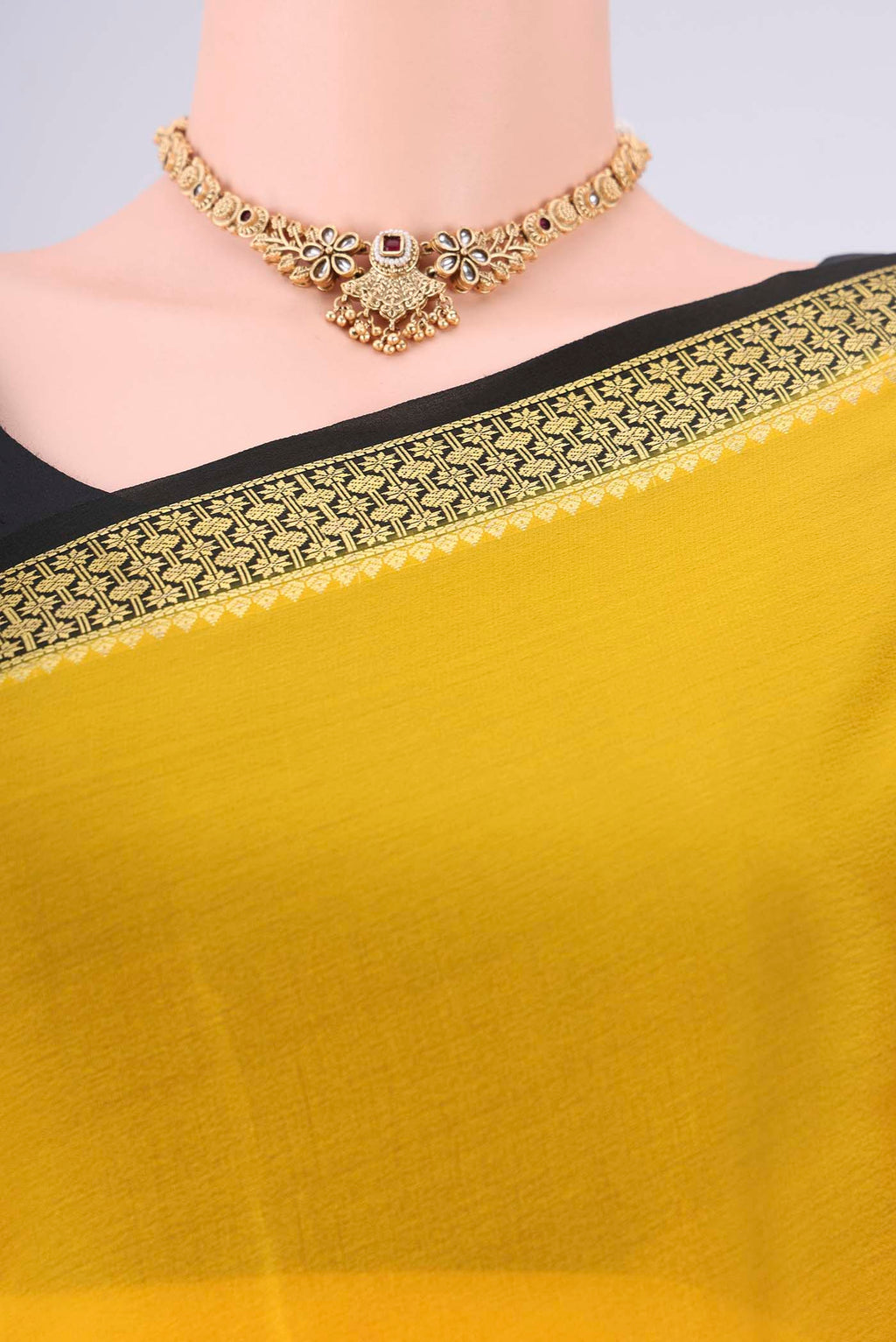 Yellow Mysore Georgette Saree with Plain Body and Zari Border.  displayed on a mannequin