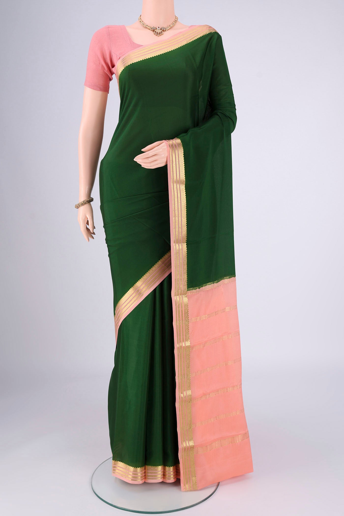 Bottle Green Mysore Georgette Saree with Zari Butta on the body and Zari Border.  displayed on a mannequin