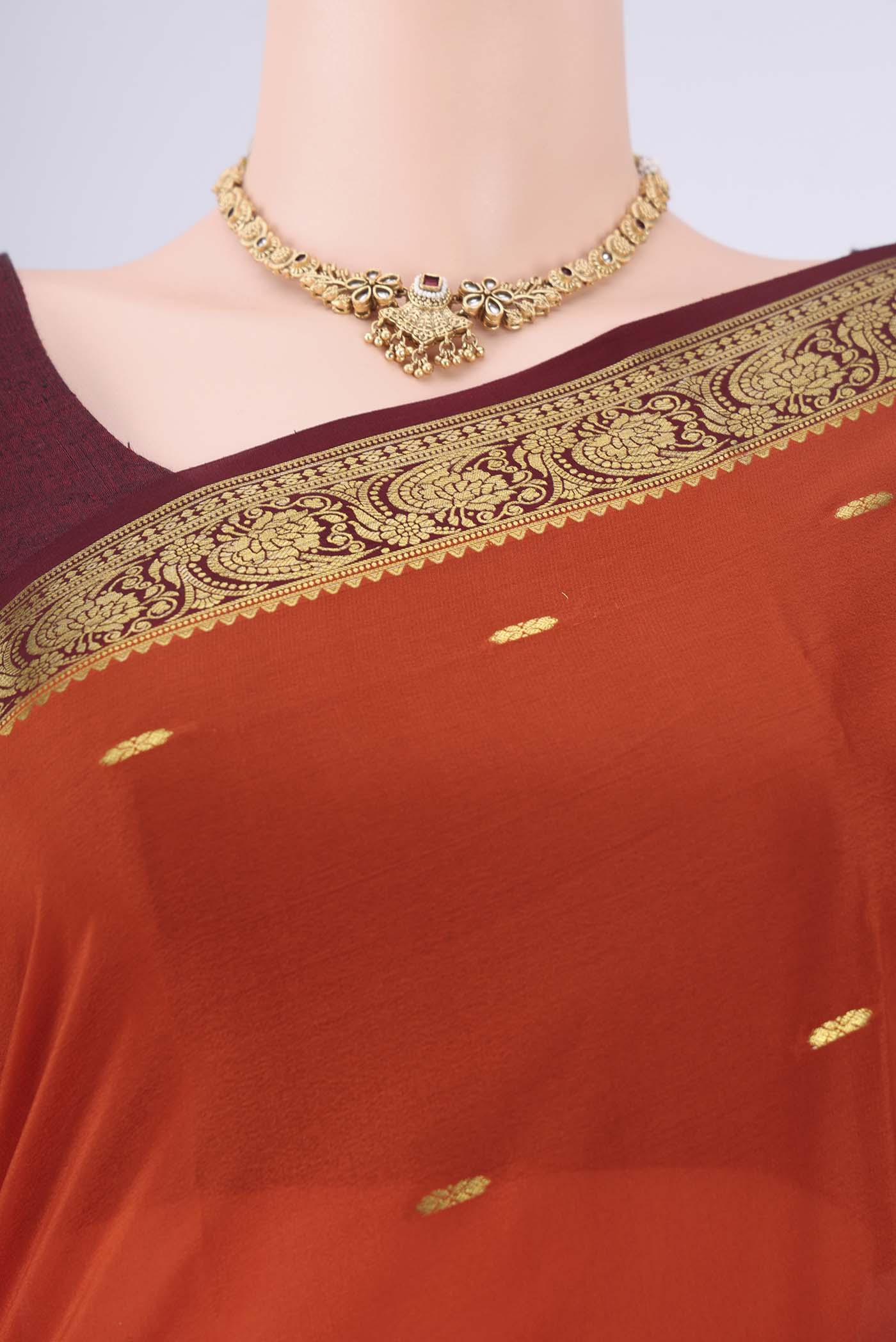 Rust Mysore Georgette Saree with Zari Butta on the body and Zari Border.  displayed on a mannequin