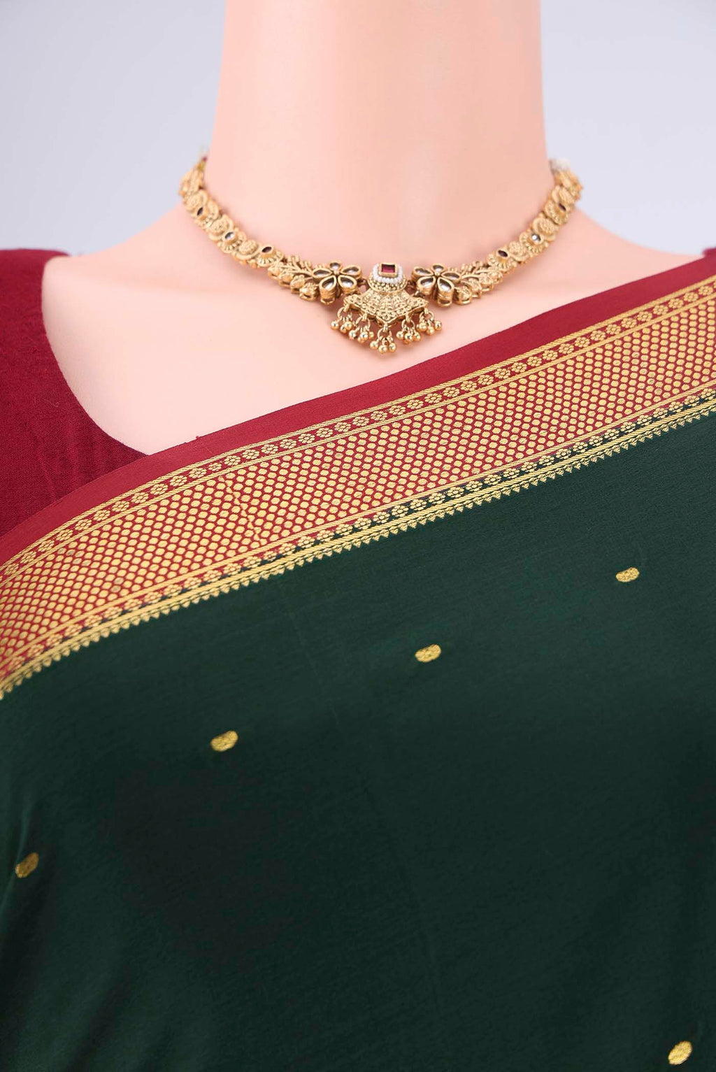 Bottle Green Mysore Georgette Saree with Zari Butta on the body and Zari Border.  displayed on a mannequin