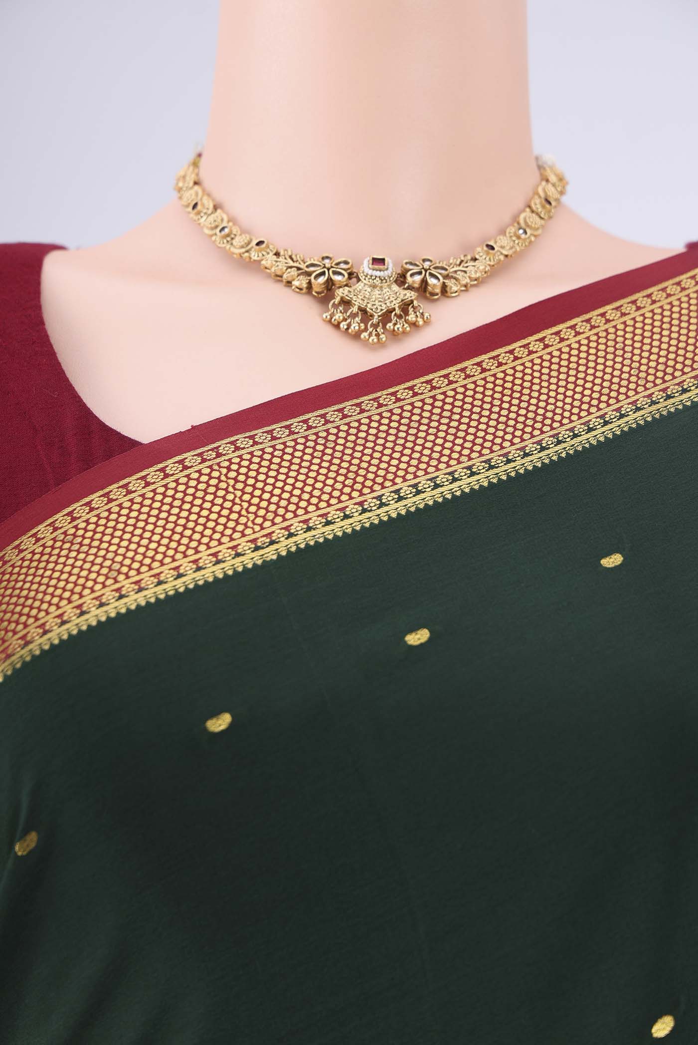 Bottle Green Mysore Georgette Saree with Zari Butta on the body and Zari Border.  displayed on a mannequin