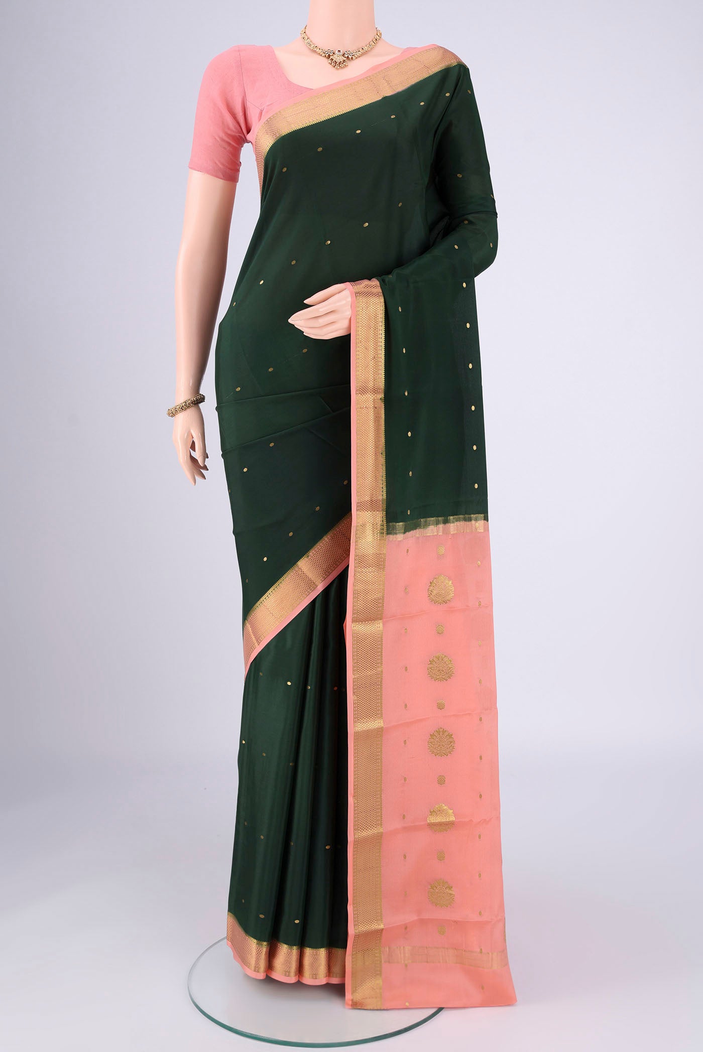 Bottle Green Mysore Georgette Saree with Zari Butta on the body and Zari Border.  displayed on a mannequin