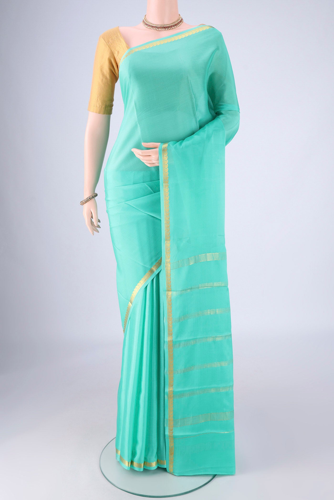 Turquoise Mysore Crepe Saree with Plain Body and Zari Border.  displayed on a mannequin