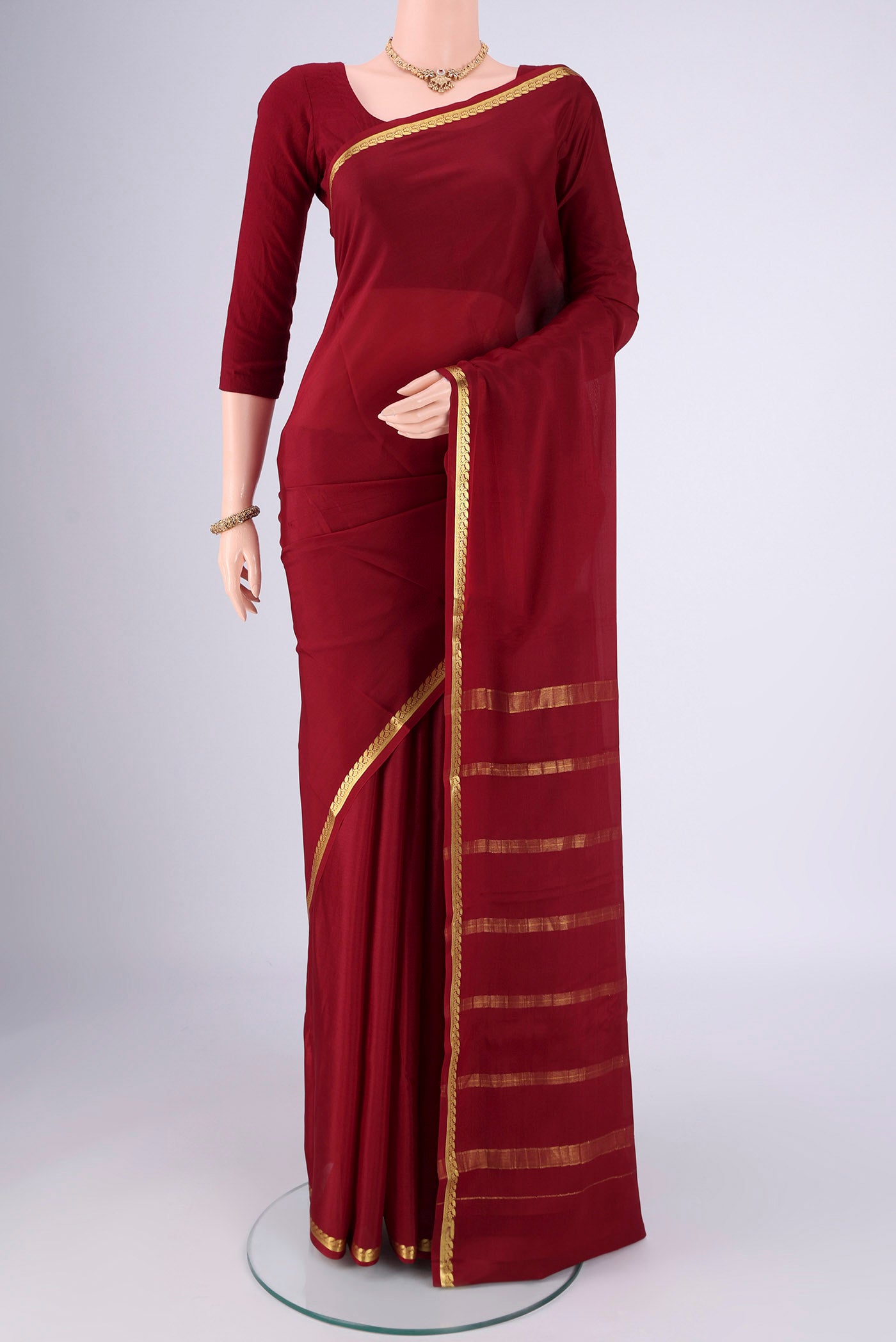 Maroon Mysore Crepe Saree with Plain Body and Zari Border.  displayed on a mannequin