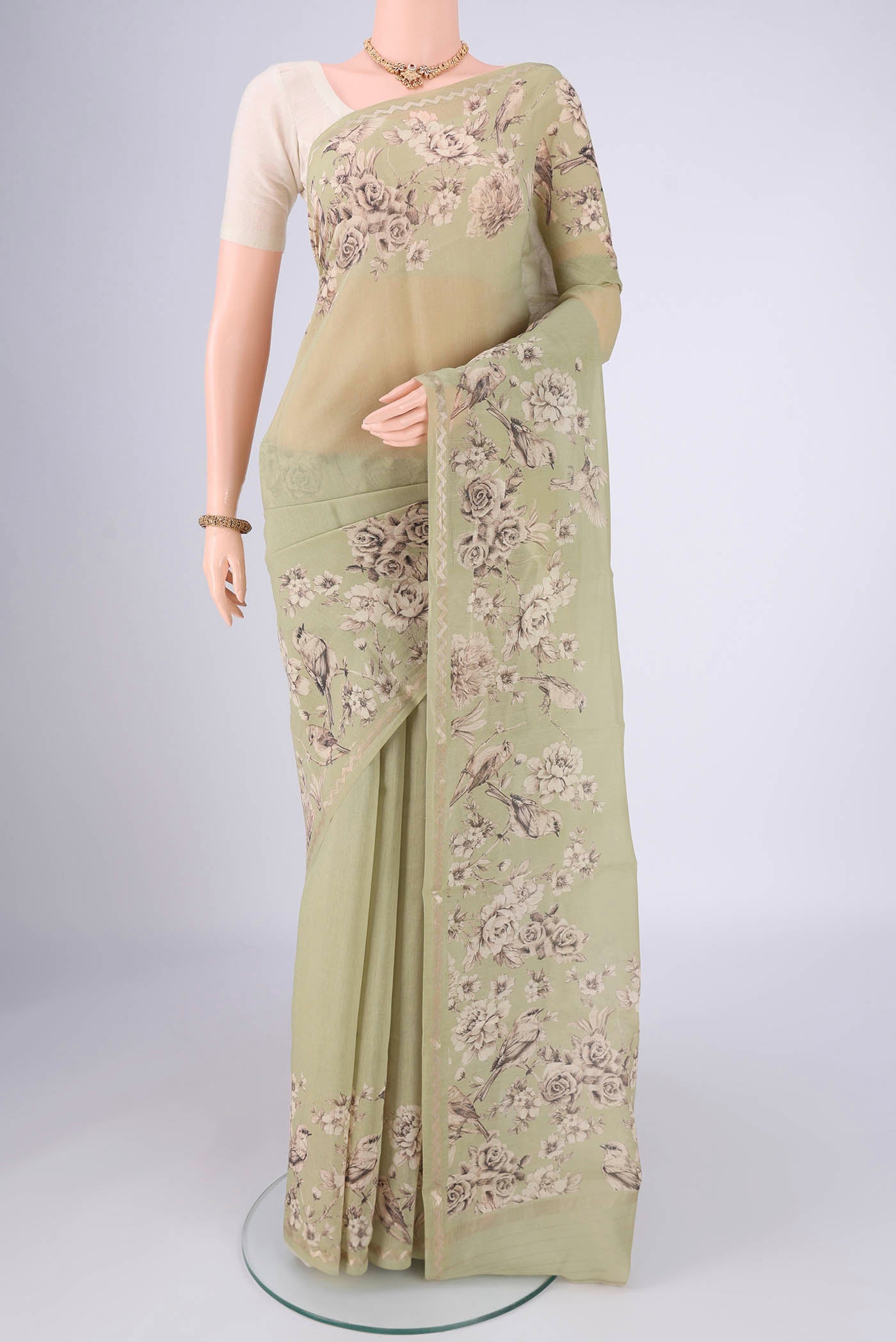 Pista Green Chanderi Silk Cotton Saree with Floral Print on the body and Zari Border.  displayed on a mannequin