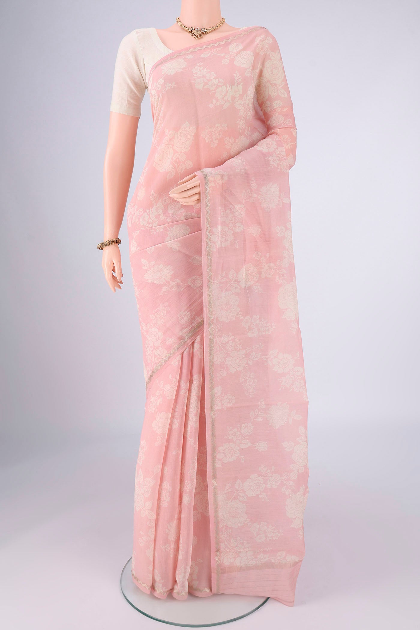 Rose pink Chanderi Silk Cotton Saree with Floral Print on the body and Zari Border.  displayed on a mannequin