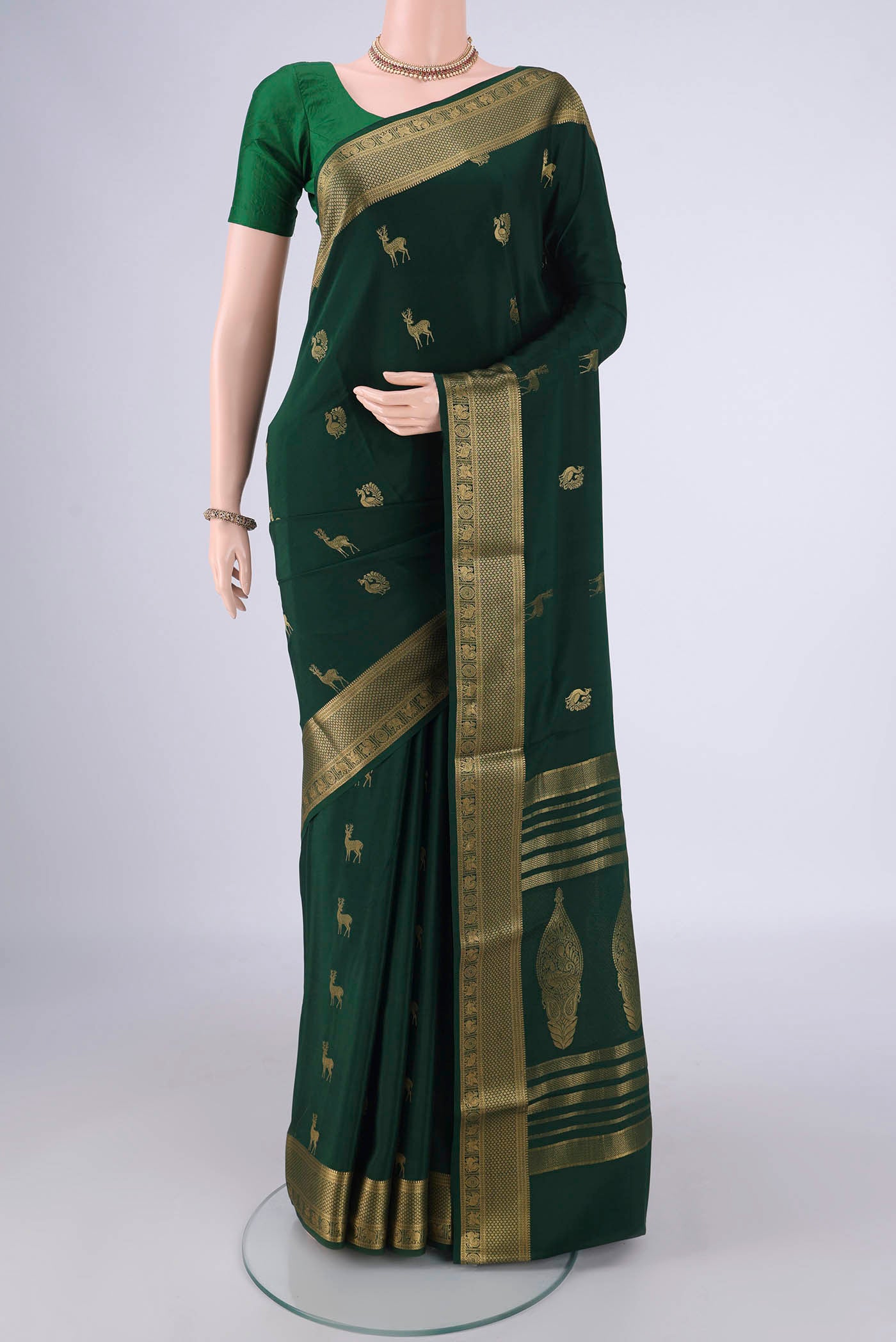 Bottle Green Mysore Crepe Saree with Zari Butta on the body and Zari Border.  displayed on a mannequin