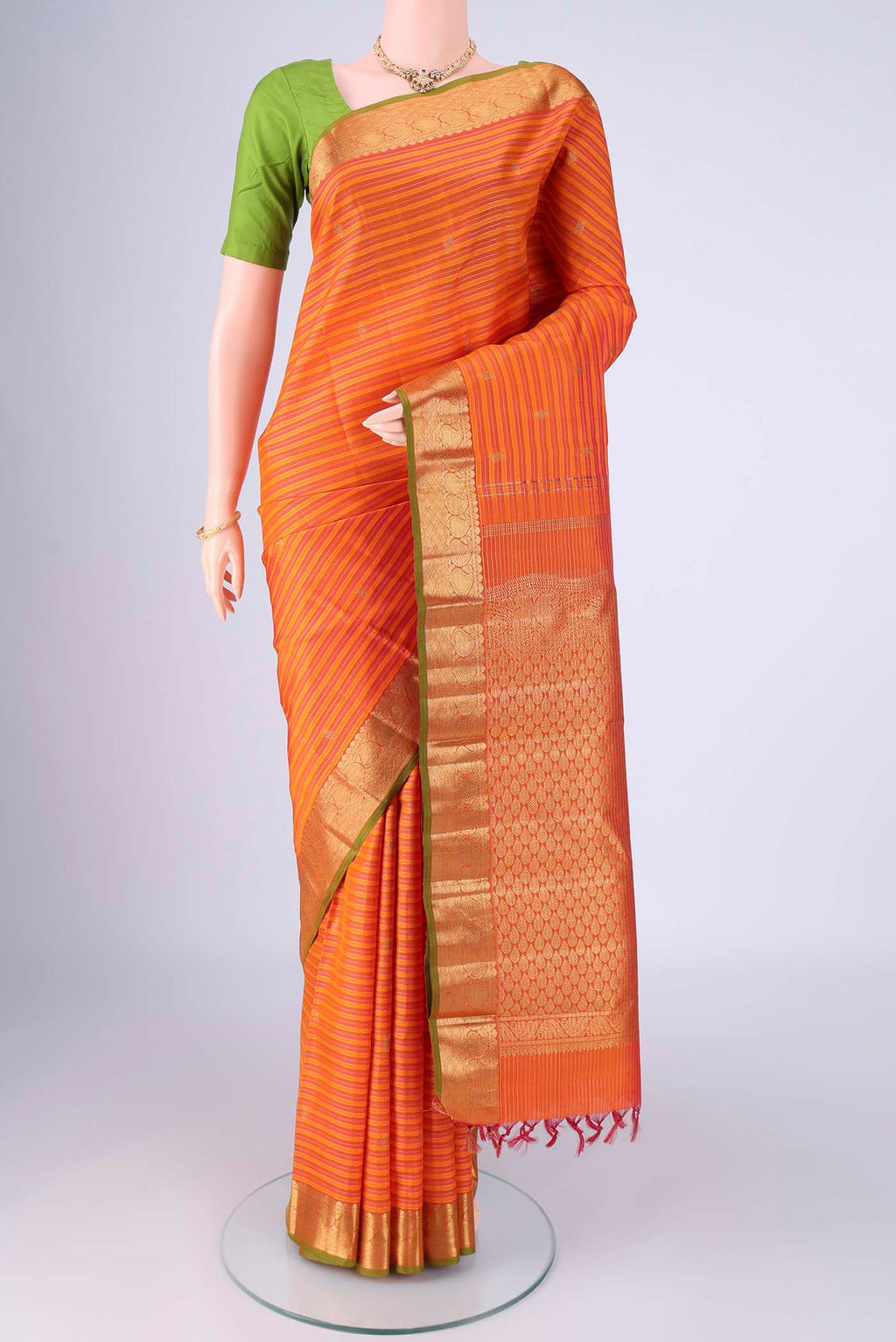 Orange Kanchipuram Silk Saree with Stripes on the body and Zari Border.  displayed on a mannequin