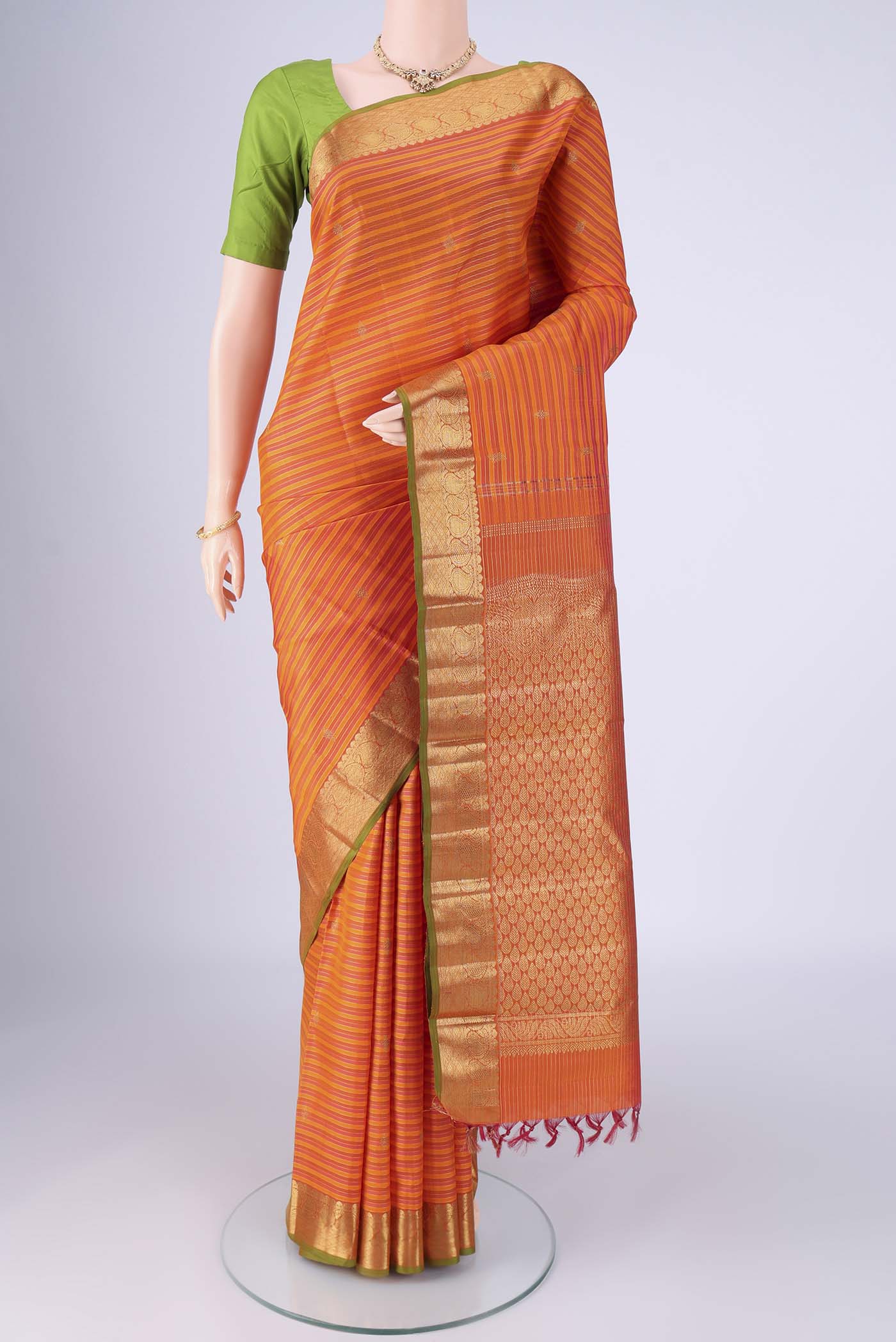 Orange Kanchipuram Silk Saree with Stripes on the body and Zari Border.  displayed on a mannequin