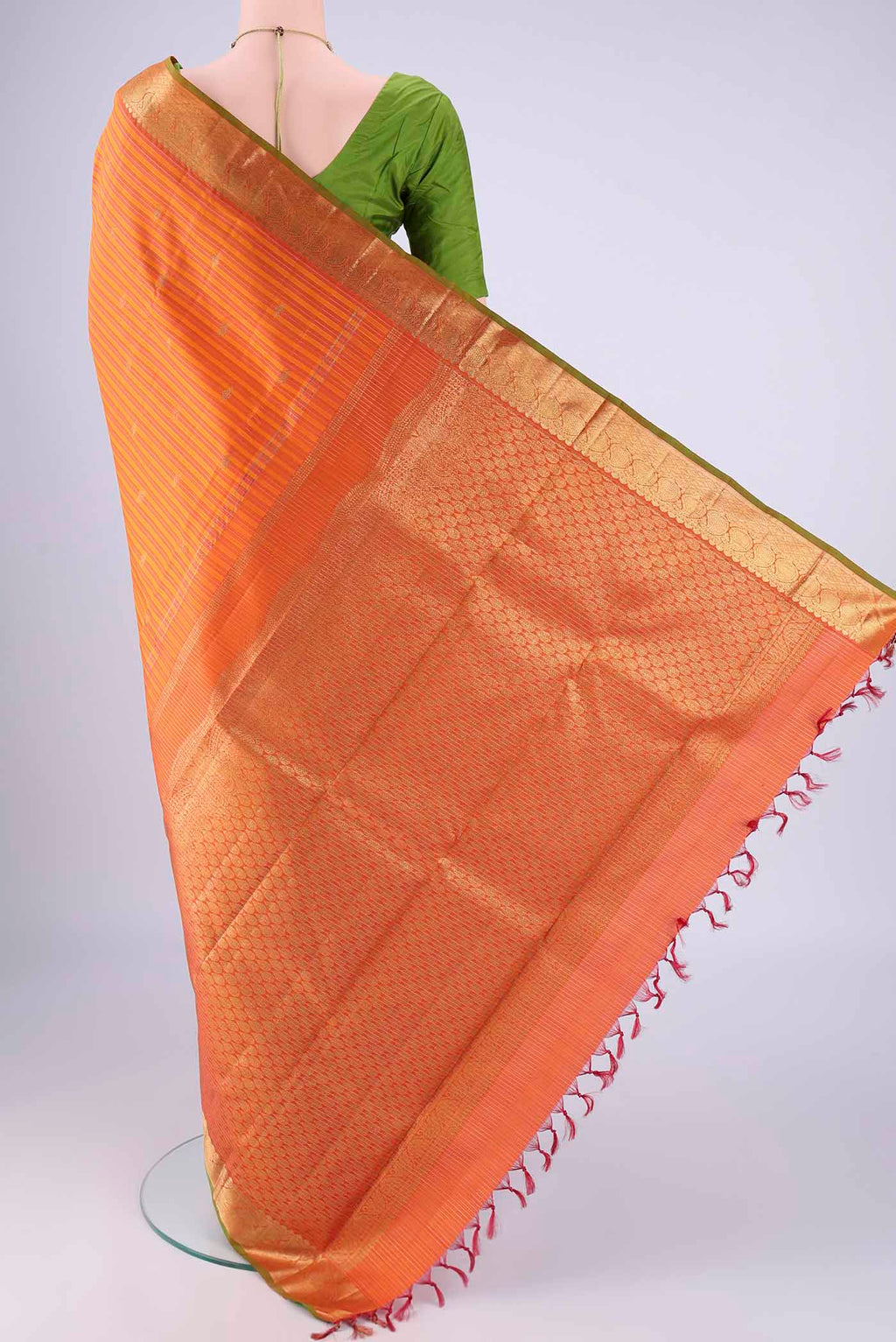 Flat view of Orange Kanchipuram Silk Saree with Stripes on the body and Zari Border. 