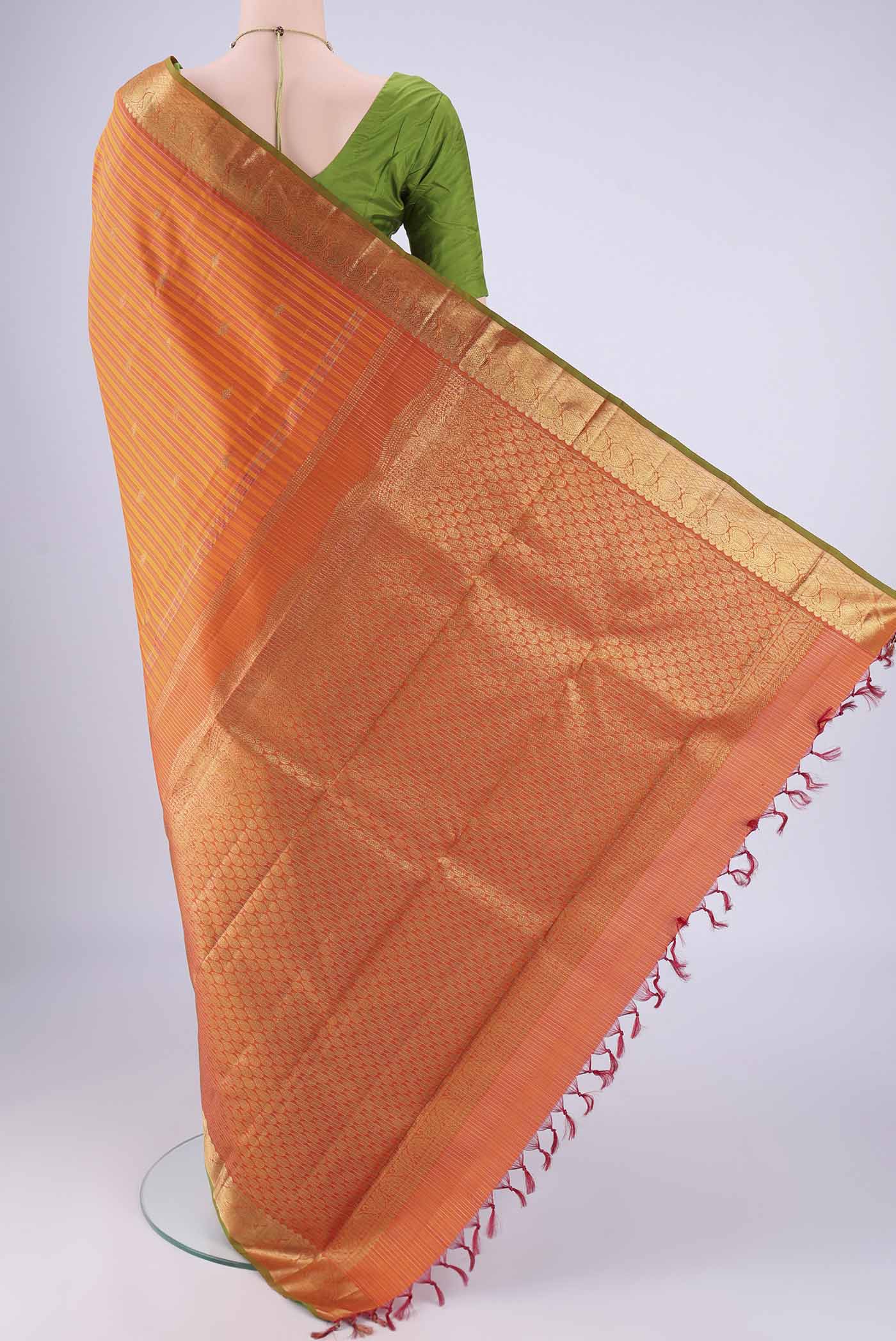 Flat view of Orange Kanchipuram Silk Saree with Stripes on the body and Zari Border. 