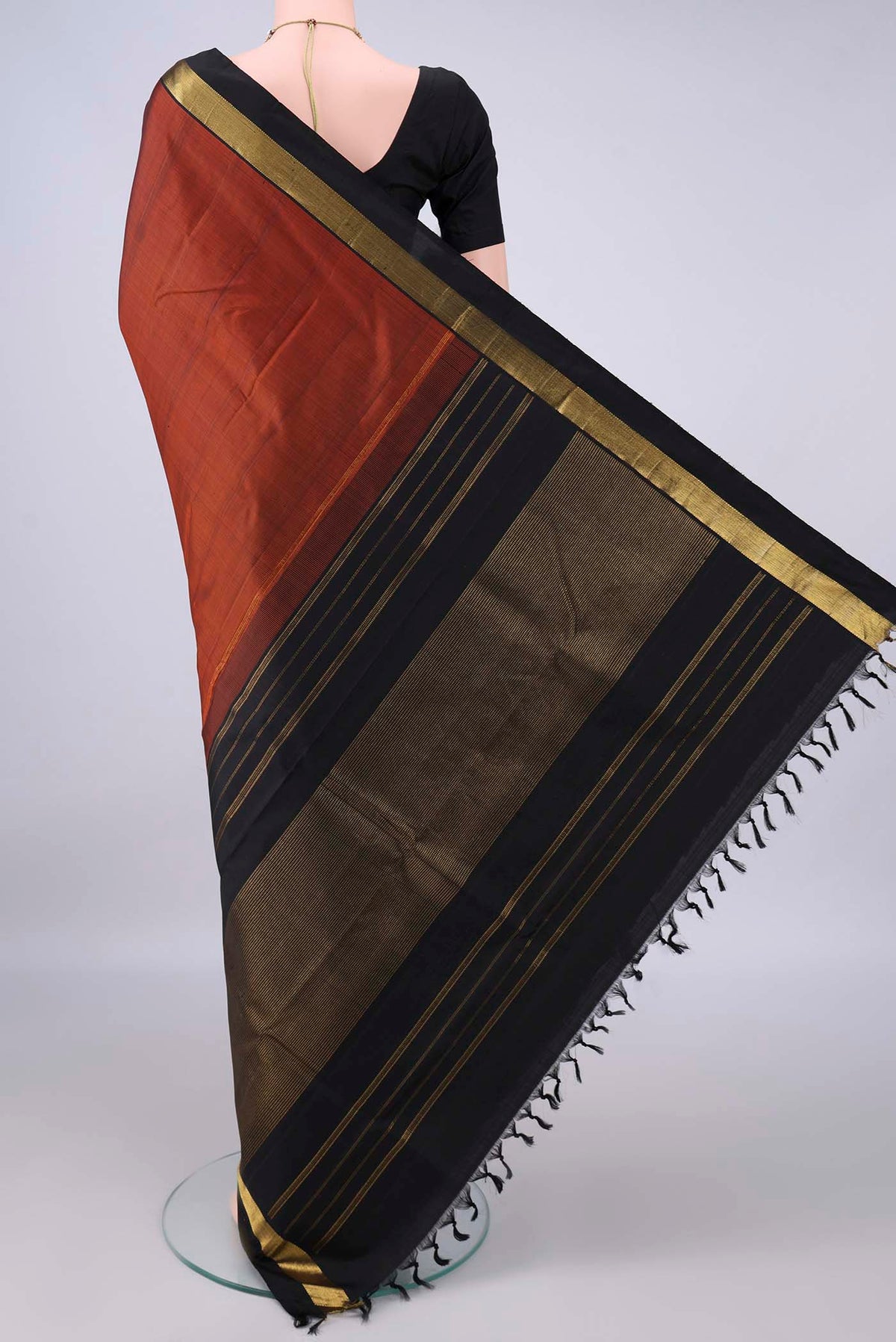 Flat view of Pure Silk Rust Kanjivaram Saree with Plain Body and Zari Border. 