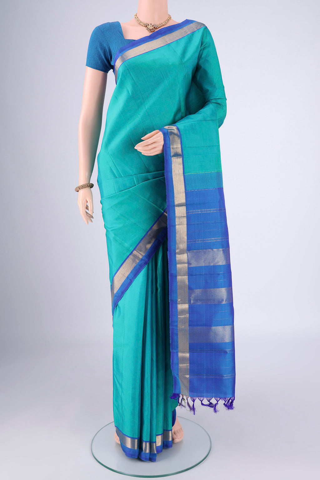 Turquoise Kanjivaram Saree with Plain Body and Zari Border.  displayed on a mannequin