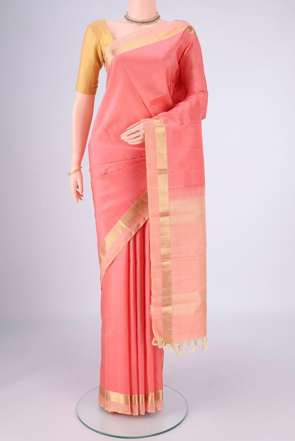 Peach Kanjivaram Silk Saree with Plain Body and Zari Border.  displayed on a mannequin