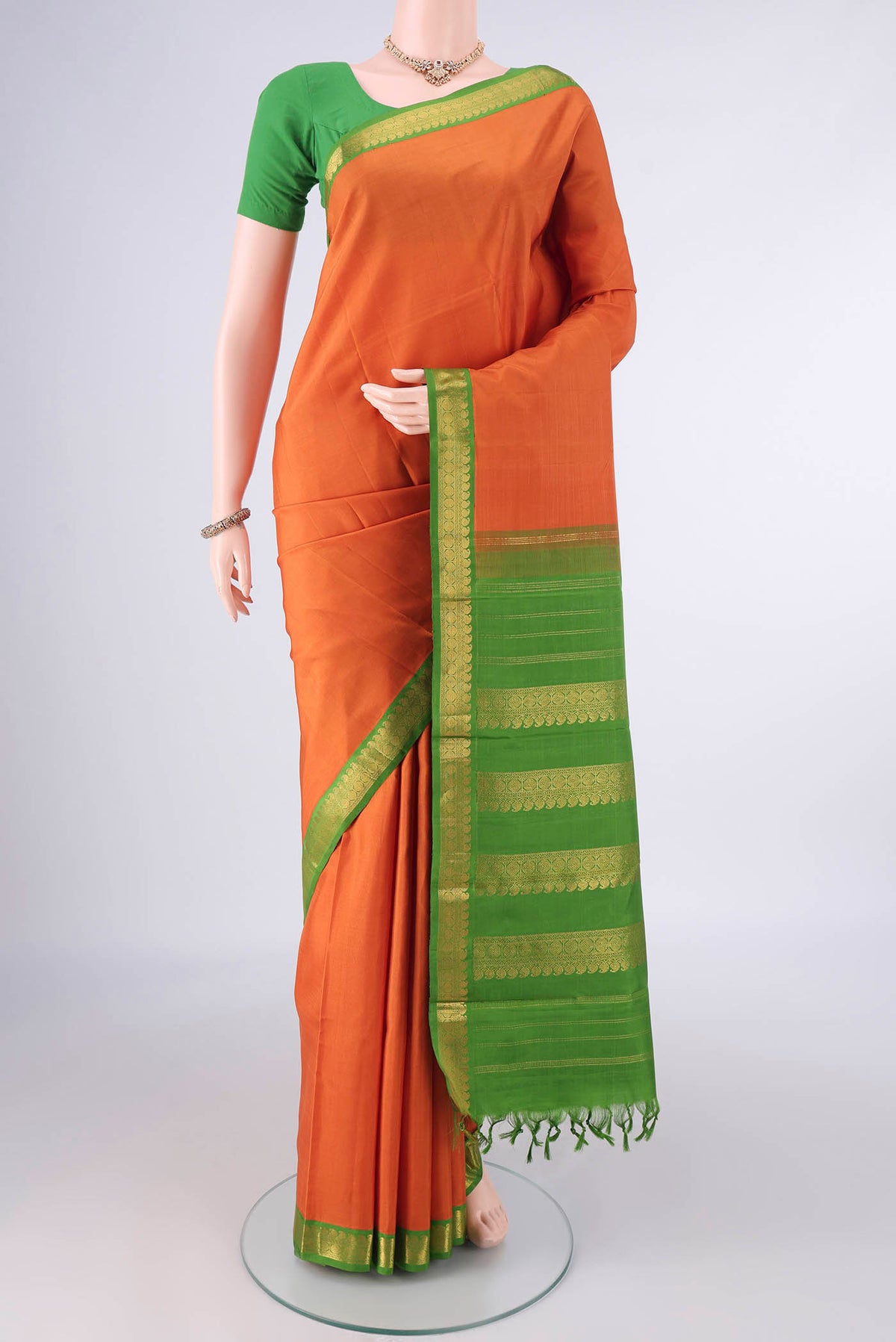 Pure Silk Orange Kanjivaram Saree with Plain Body and Zari Border.  displayed on a mannequin