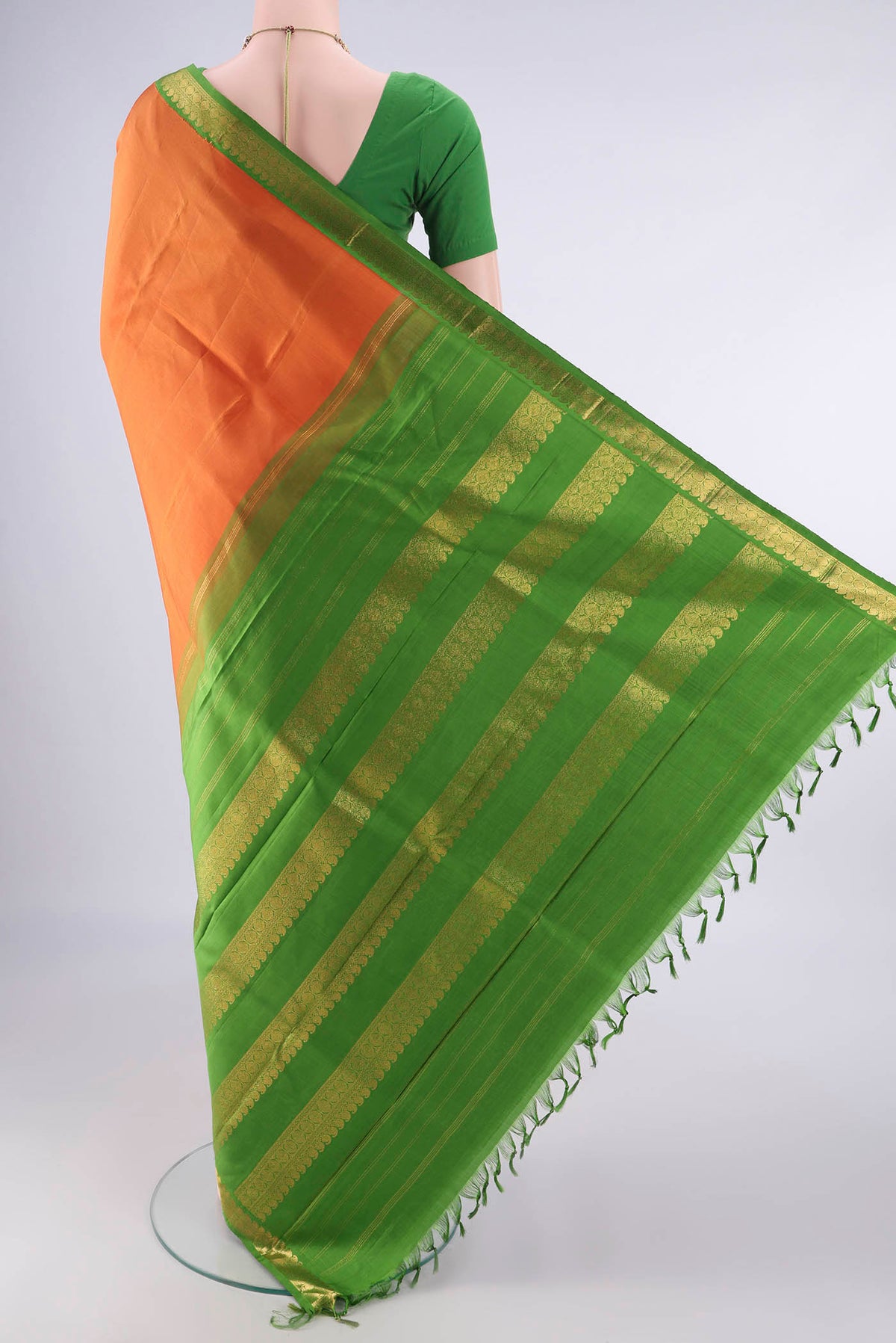 Flat view of Pure Silk Orange Kanjivaram Saree with Plain Body and Zari Border. 