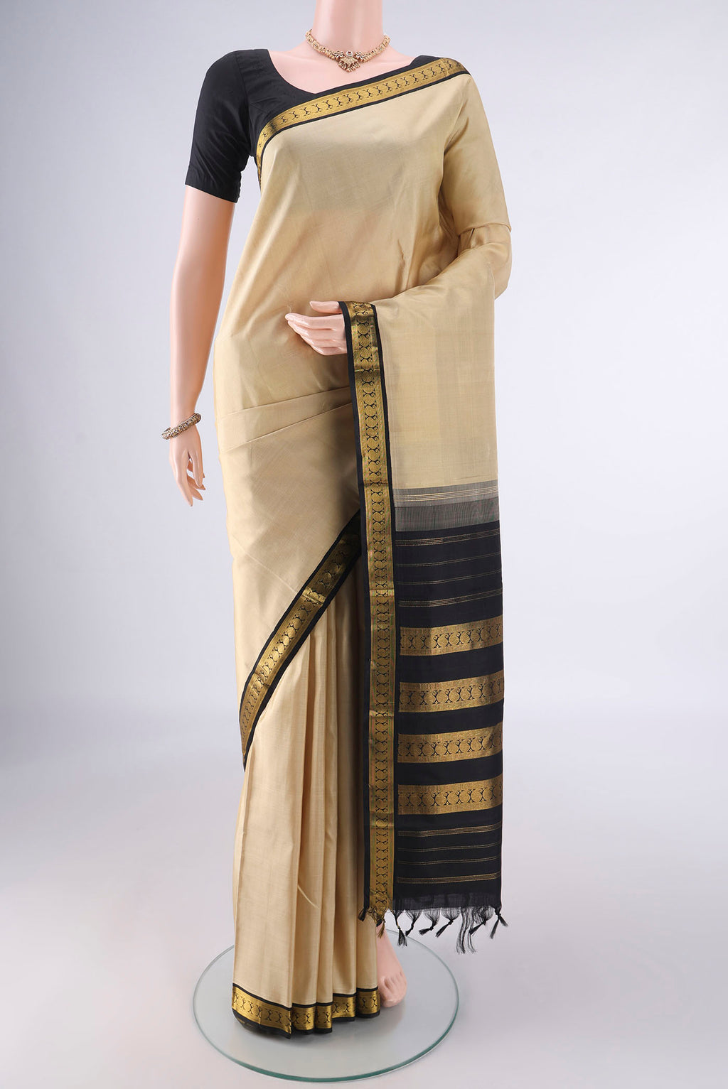 Pure Silk Beige Kanjivaram Saree with Plain Body and Zari Border.  displayed on a mannequin