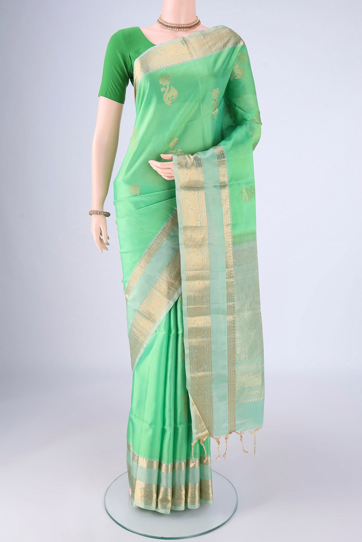 Mint Green Soft Silk Saree with Zari Butta on the body and Zari Border.  displayed on a mannequin
