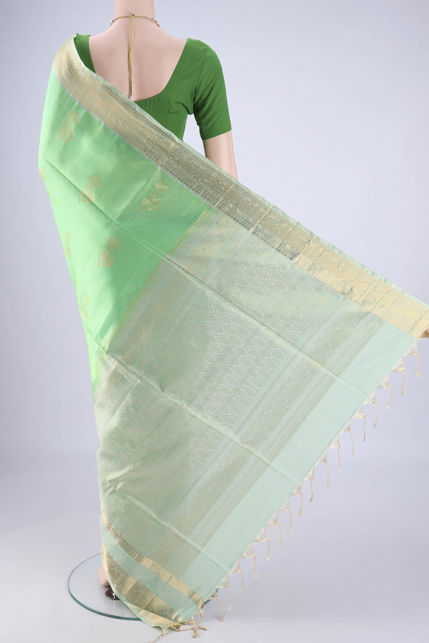 Flat view of Mint Green Soft Silk Saree with Zari Butta on the body and Zari Border. 