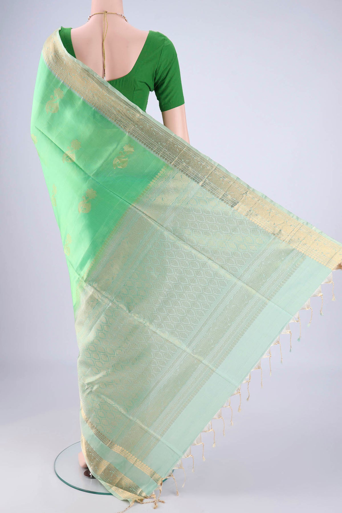 Flat view of Mint Green Soft Silk Saree with Zari Butta on the body and Zari Border. 