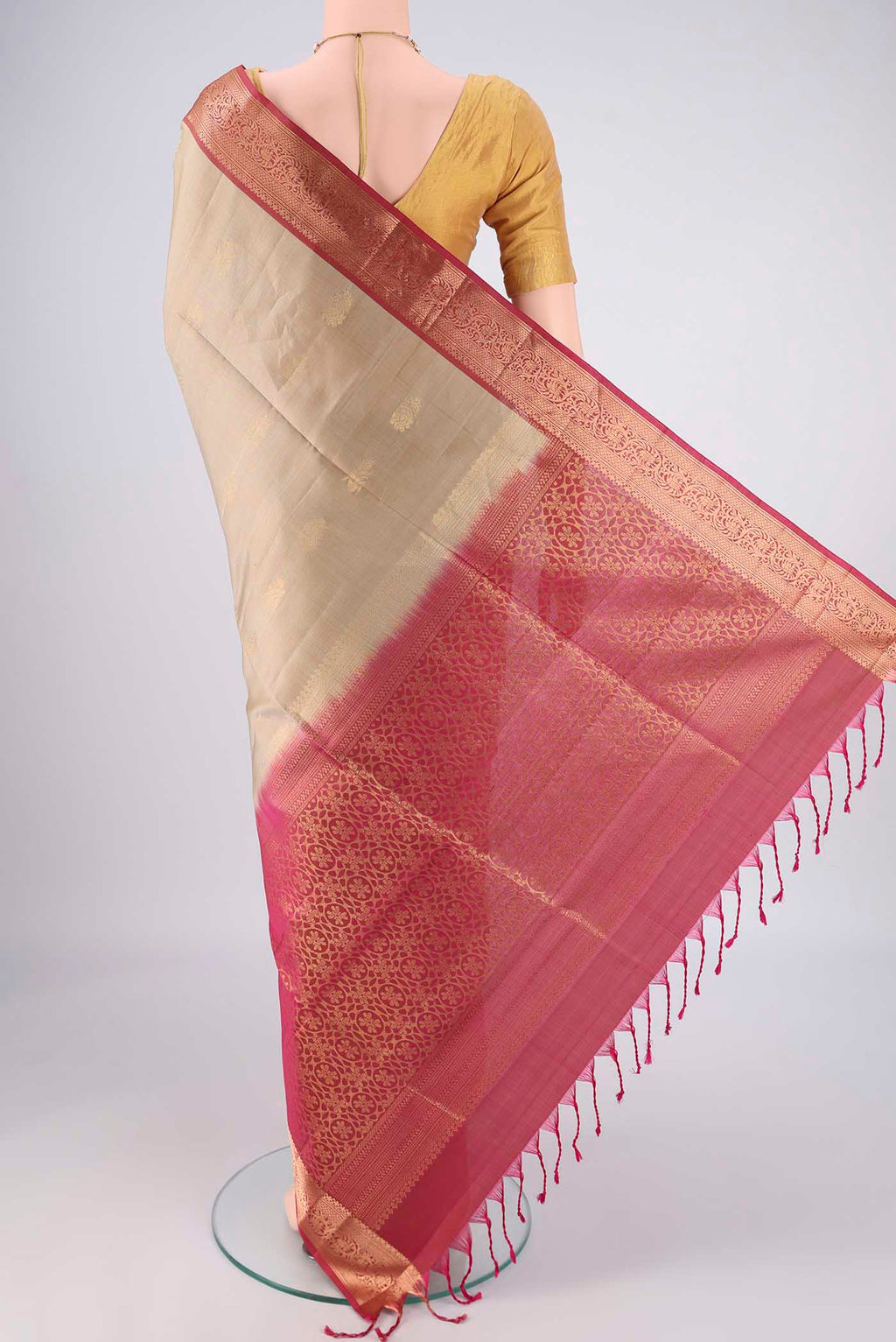 Flat view of Beige Soft Silk Saree with Zari Butta on the body and Zari Border. 