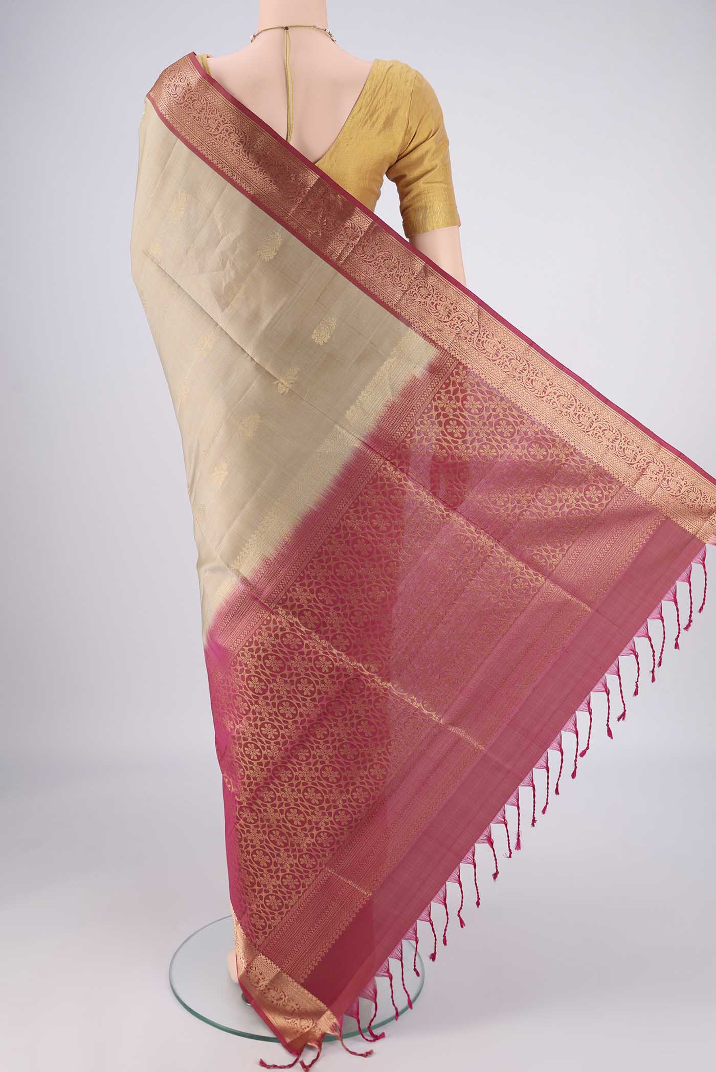 Flat view of Beige Soft Silk Saree with Zari Butta on the body and Zari Border. 