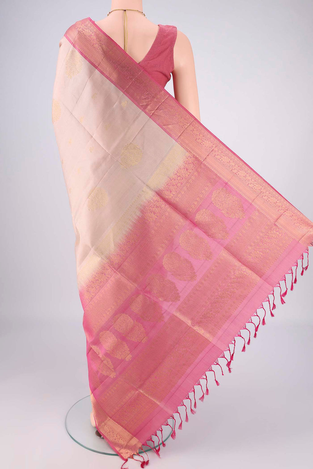 Flat view of Beige Soft Silk Saree with Zari Butta on the body and Zari Border. 
